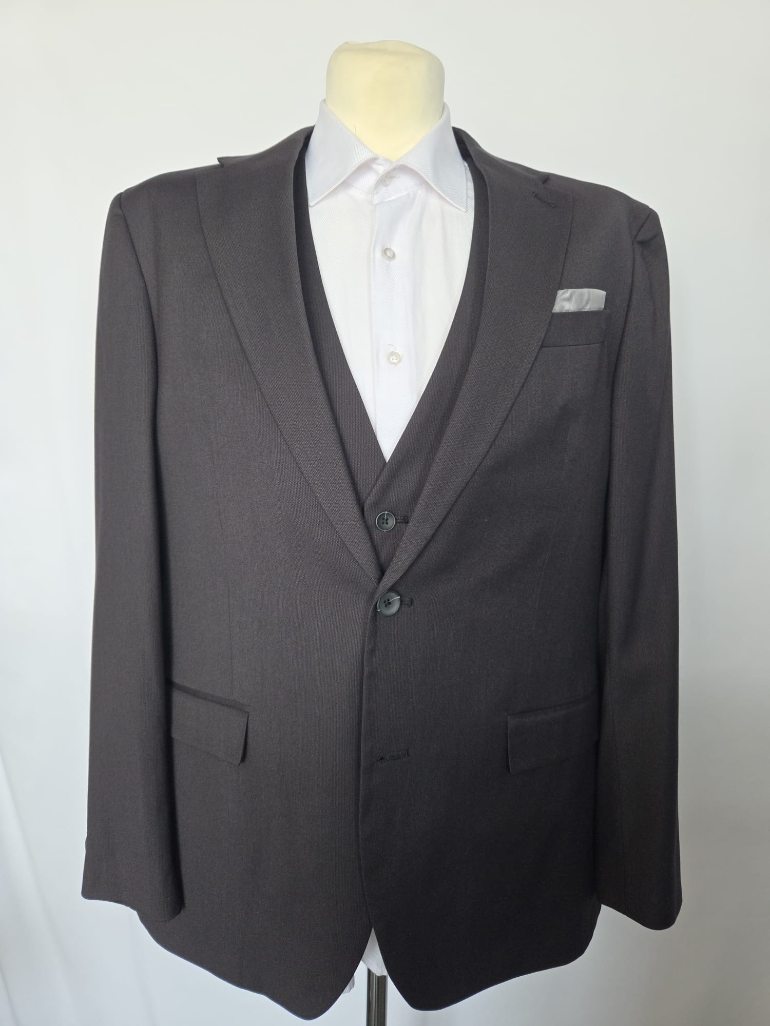 Straight-on front view of black suit jacket with waistcoat peeking, two-button closure, regular fit.