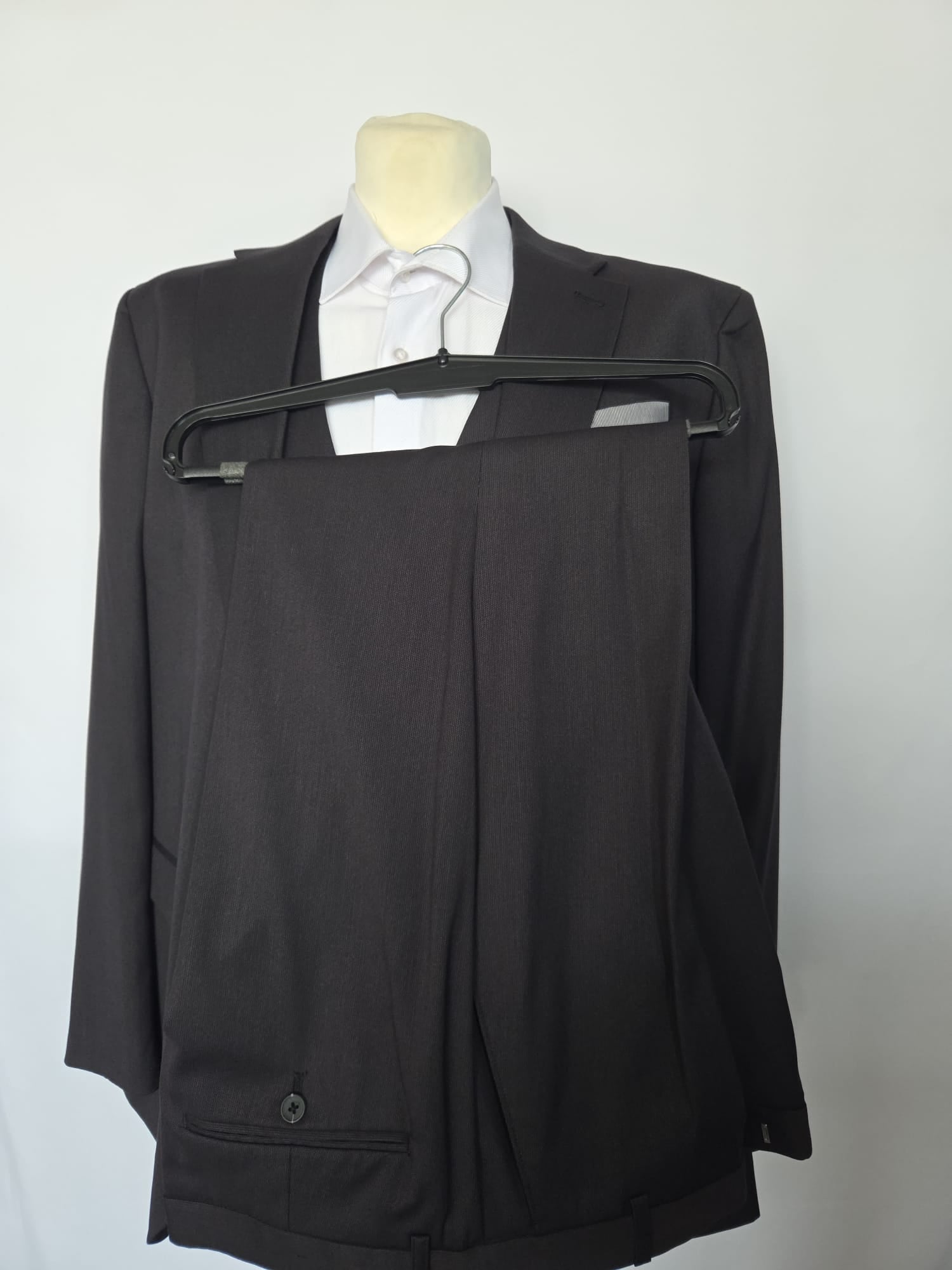 Black Thomas Goodwin three-piece suit displayed with matching trousers on hanger.