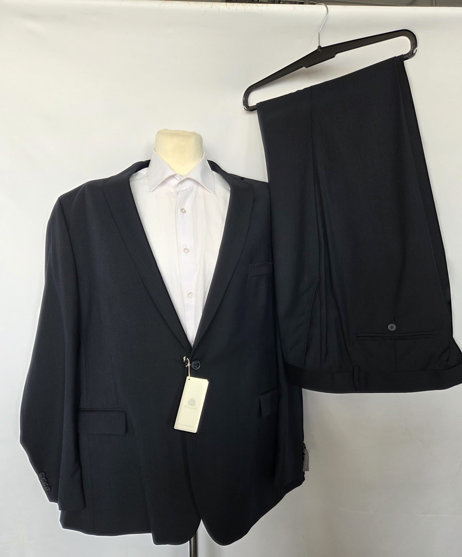 Dark navy Thomas Goodwin two-piece suit displayed with matching trousers on hanger.
