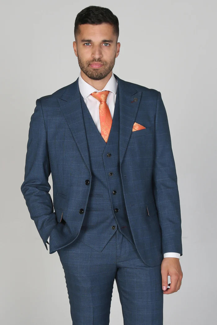 Close-up of a man in a navy three-piece suit showing the tailored fit, orange paisley tie, and coordinated pocket square.