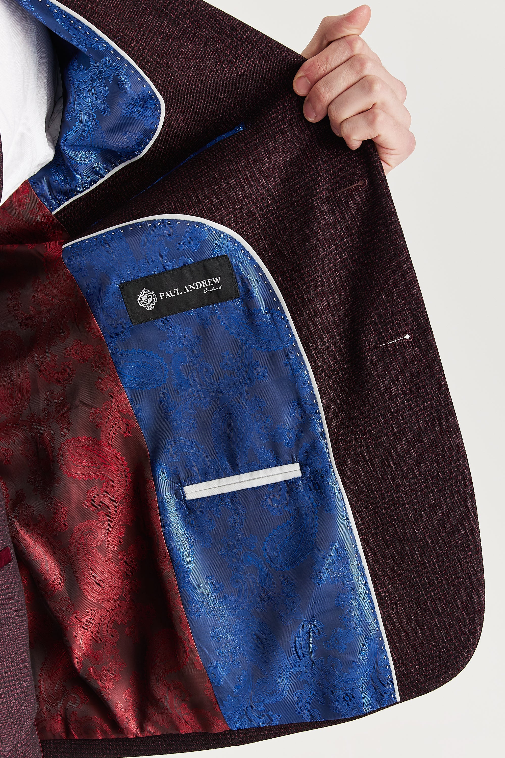 Interior view of the wine check blazer with blue and wine paisley lining, a visible Paul Andrew logo label and matching trim along the inner pocket opening.