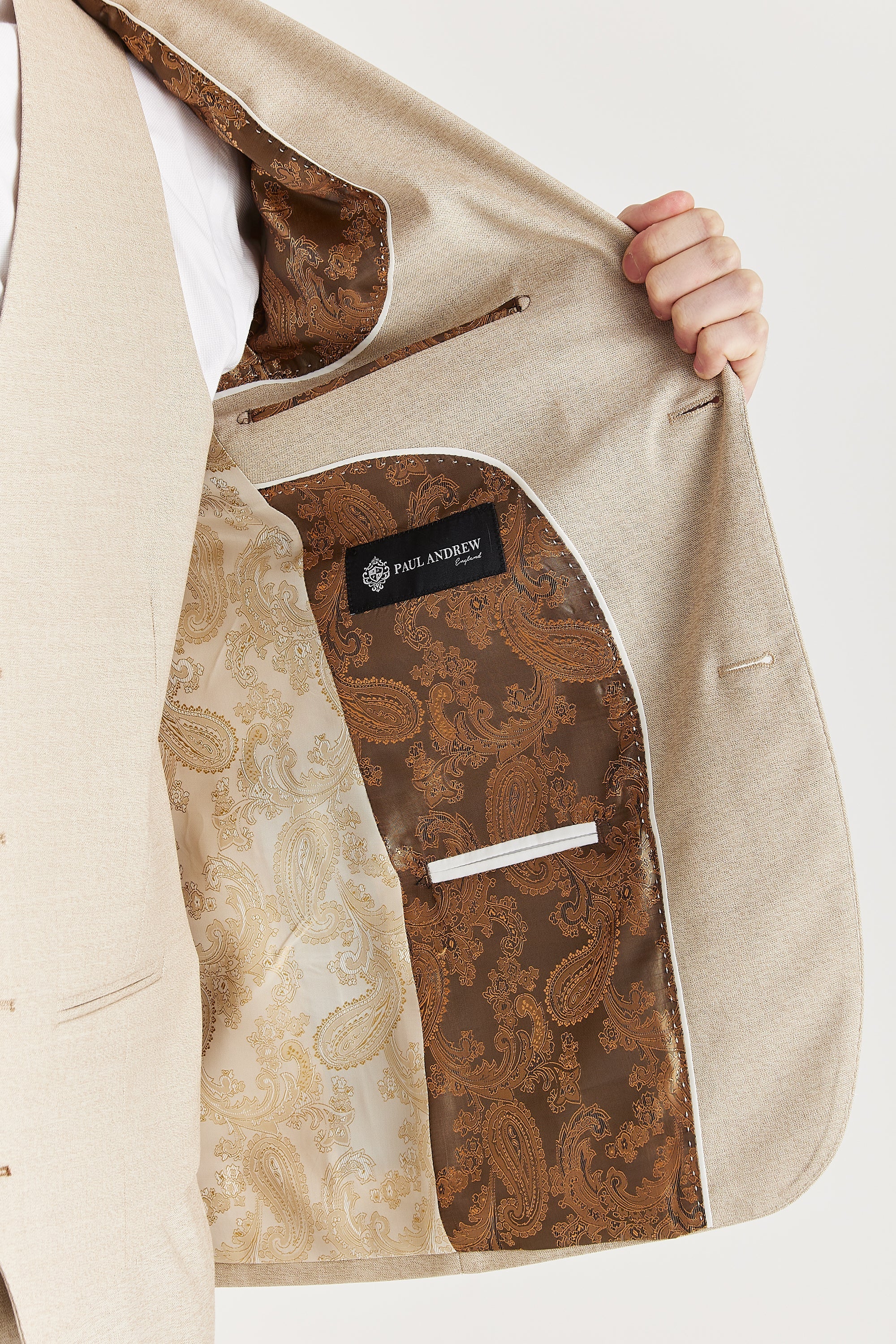 Interior view of the beige blazer with two-tone paisley lining in cream and brown, and a visible Paul Andrew logo label.