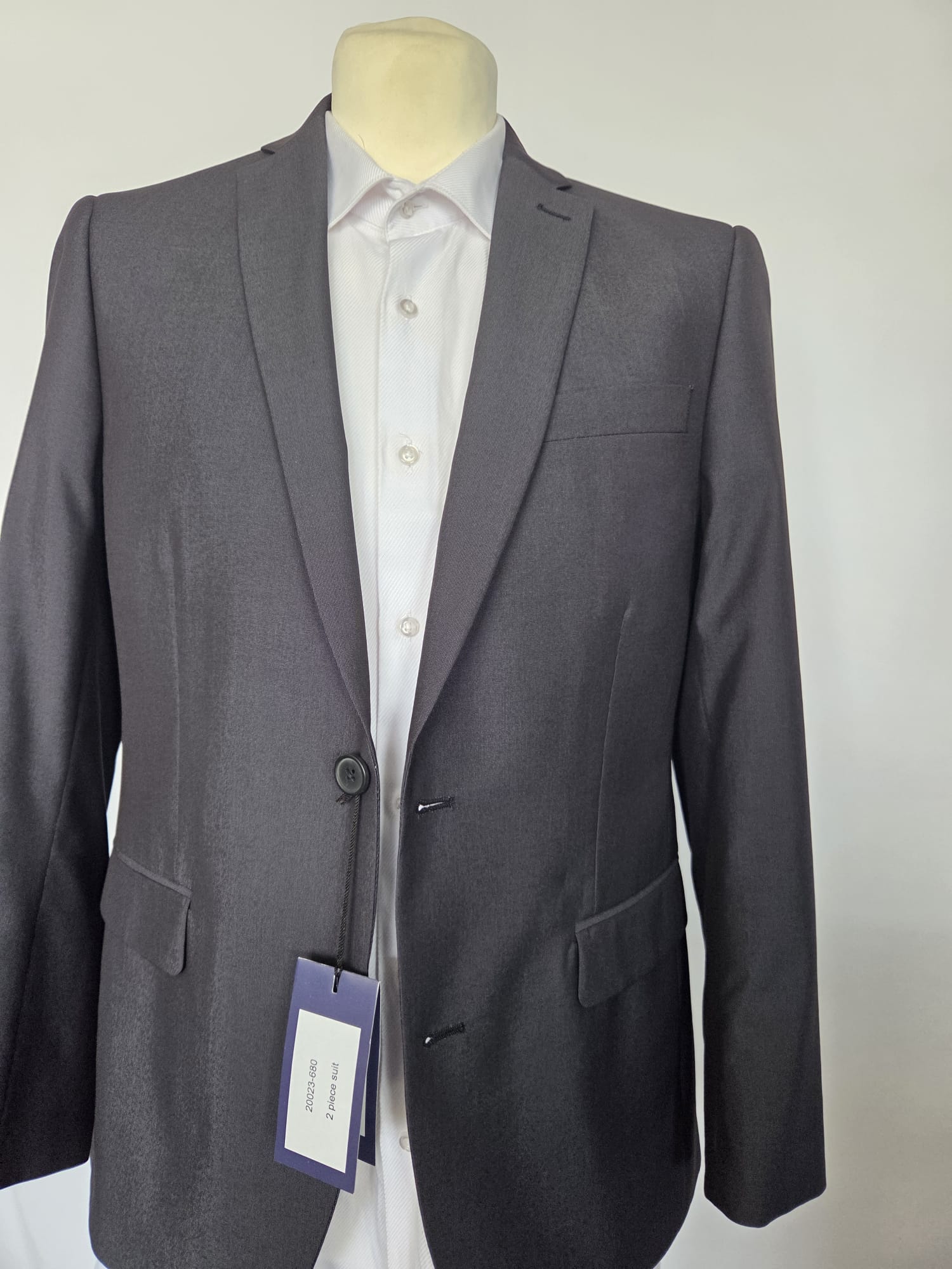 Straight-on front of dark grey two-piece suit jacket with notched lapel and flap pockets.