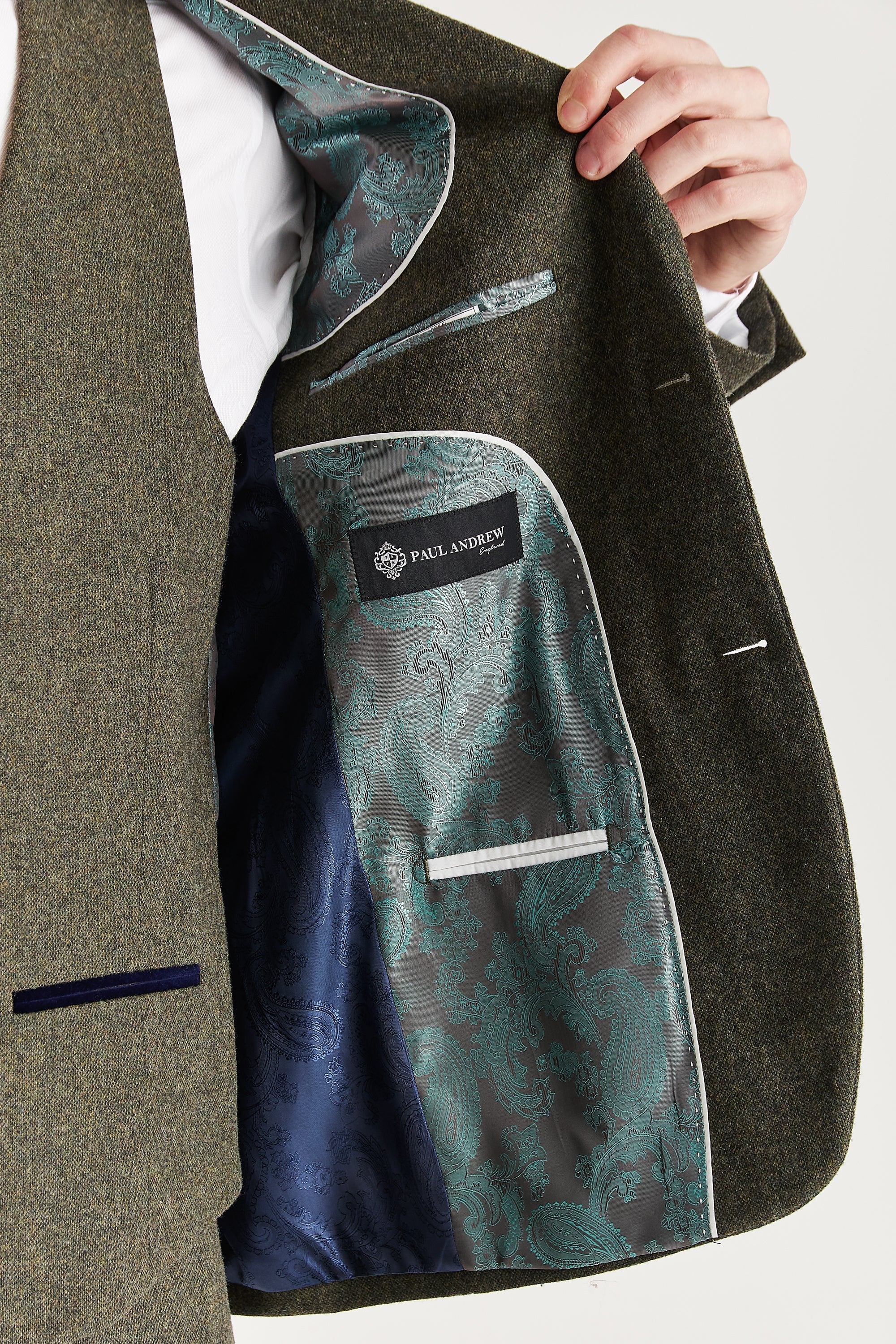 Interior view of the green tweed blazer with sage and navy paisley lining and a visible Paul Andrew logo label.