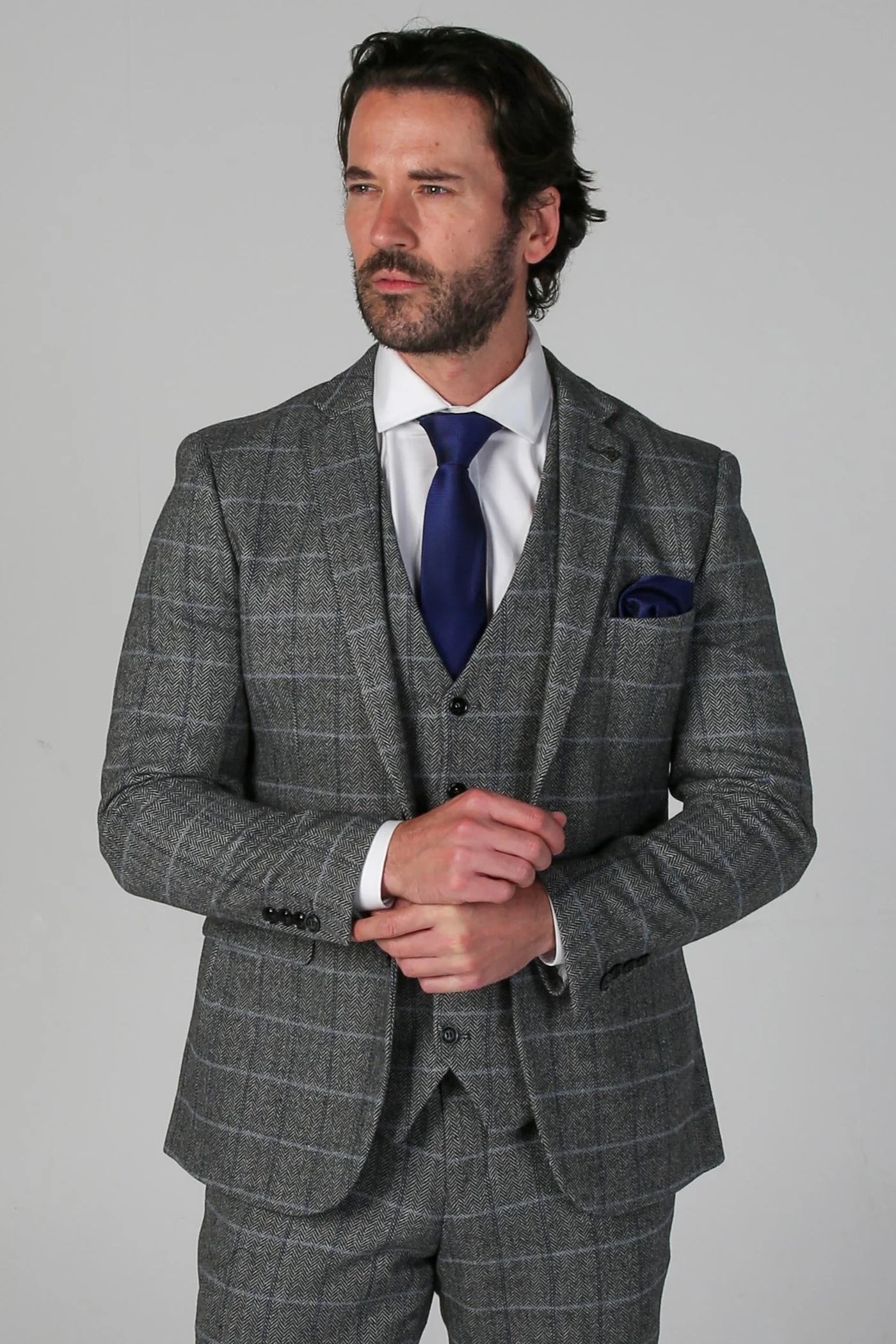 Close-up front view of the Harris Grey Tweed Check three-piece suit, featuring a blue tie and matching pocket square for a polished look.