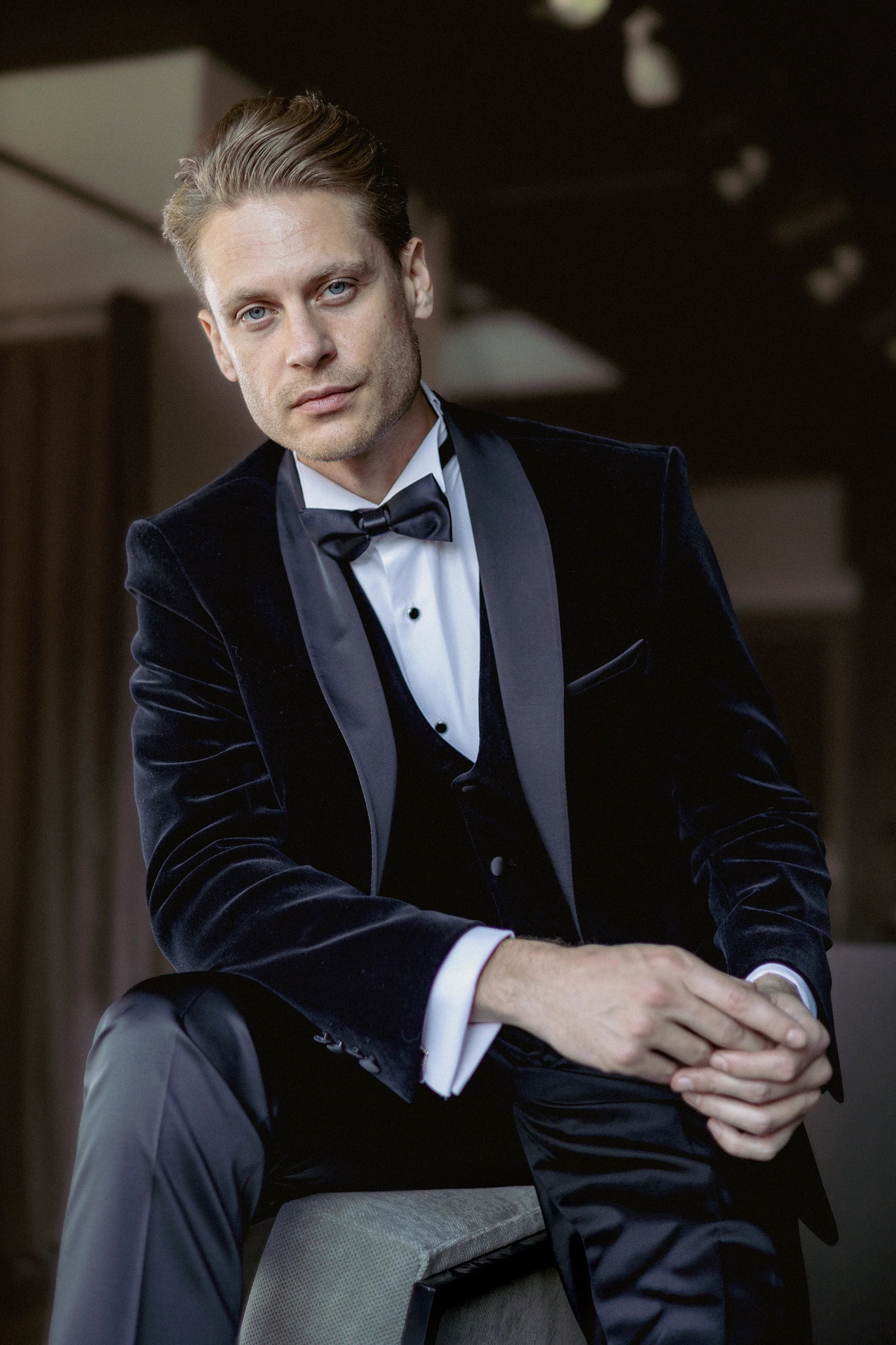 Black velvet dinner jacket with black satin shawl lapels and matching waistcoat, seated view