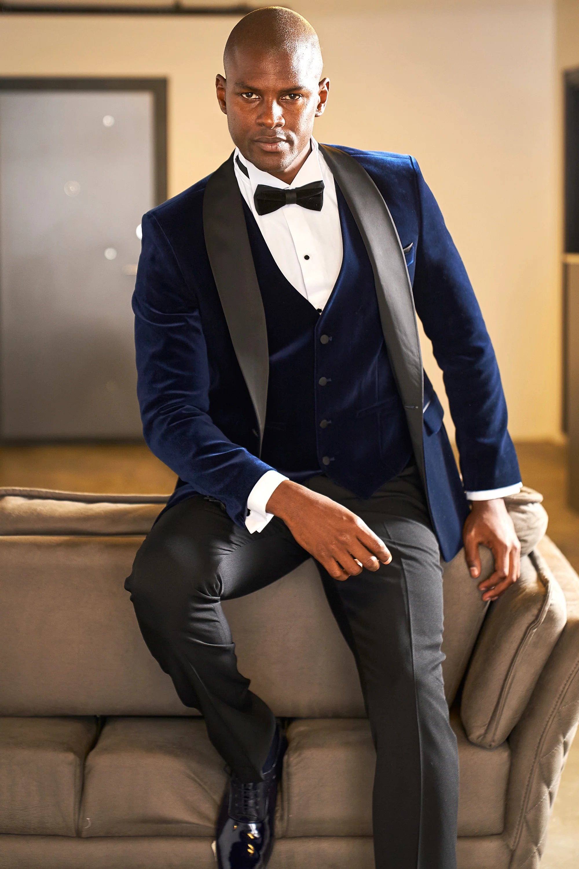 Midnight blue velvet dinner jacket with black satin shawl lapels and matching waistcoat, seated view