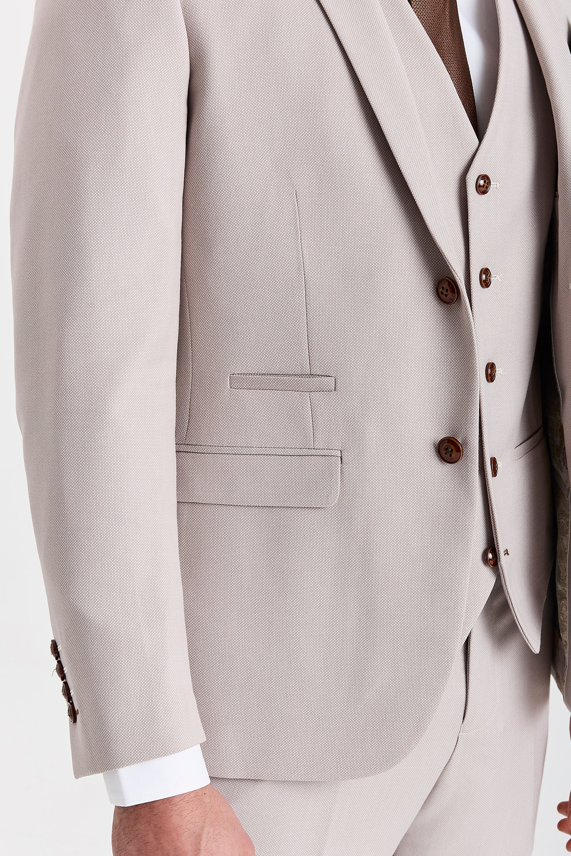 Close-up view of the Mayfair stone textured blazer showing the finely woven surface, brown buttons, a front flap pocket and an upper pocket detail.