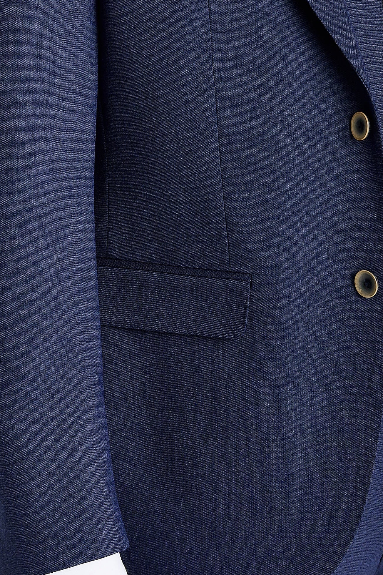 Close-up view of the navy blazer showing the smooth woven surface, front flap pocket and buttons.