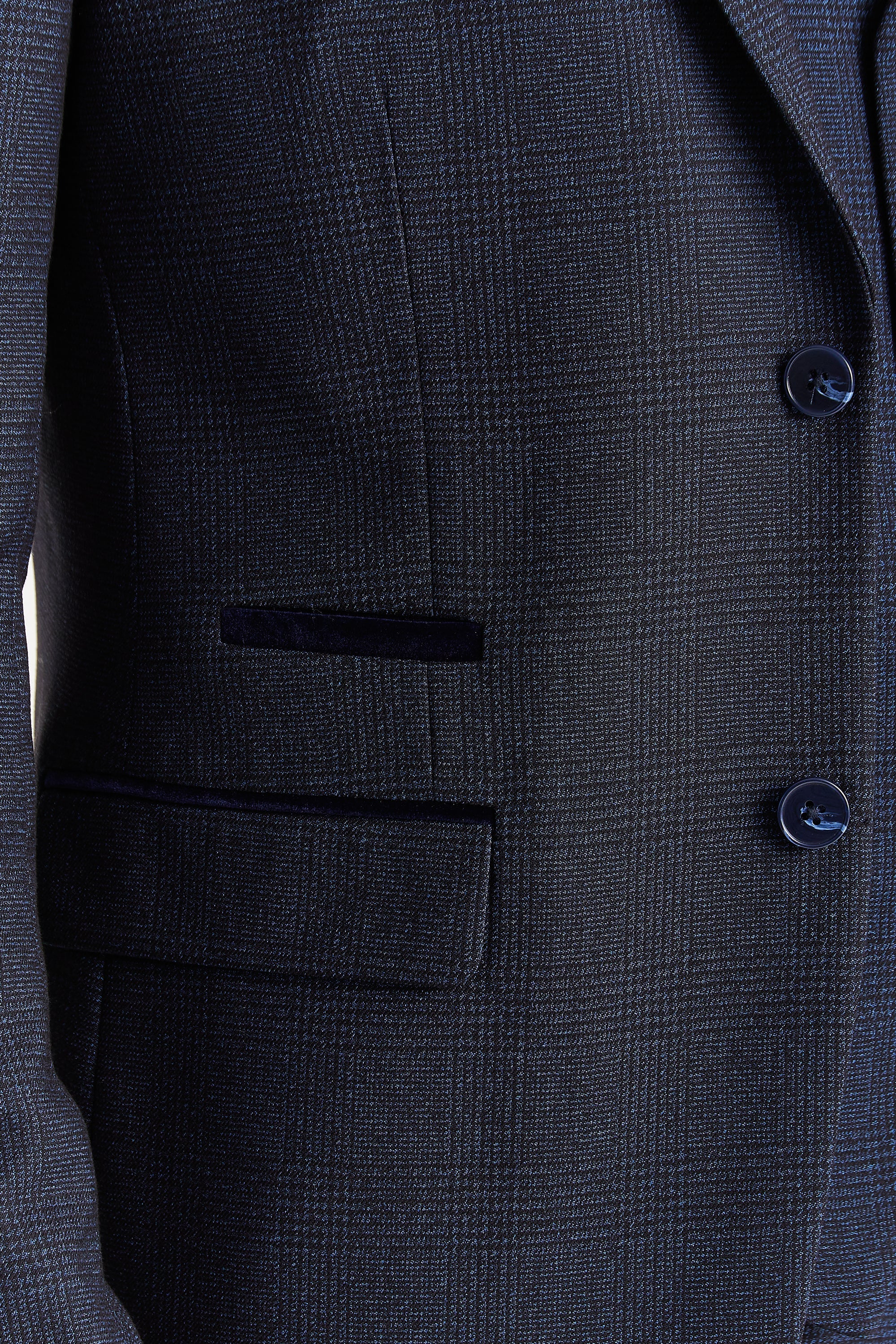 close-up view of the navy glen check blazer showing the woven check pattern, front flap pocket, dark trim detail and dark Navy buttons.