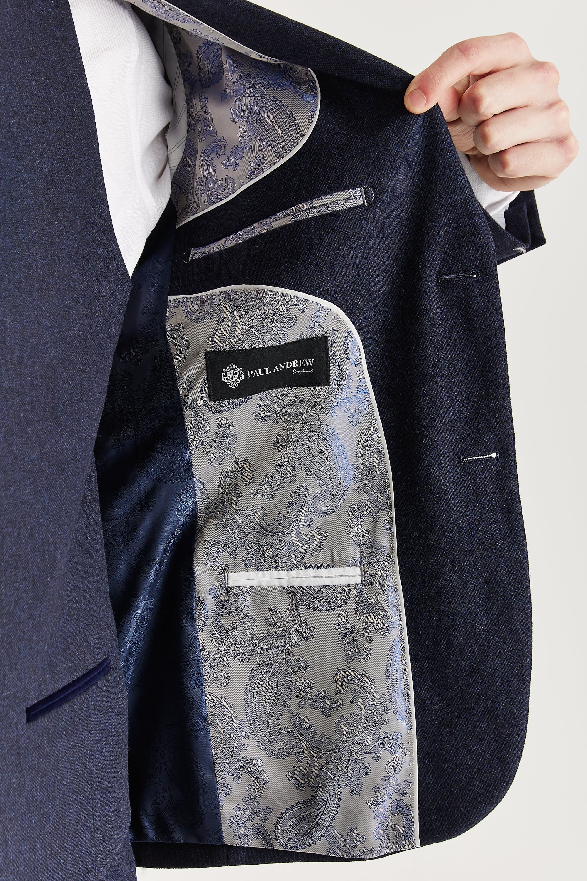 Interior view of the navy tweed blazer with silver and navy paisley lining and a visible Paul Andrew logo label.