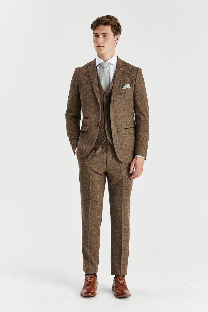 Full front view of Oscar brown tweed three-piece suit with matching trousers and waistcoat, paired with white shirt and light green tie and brown brogues. 