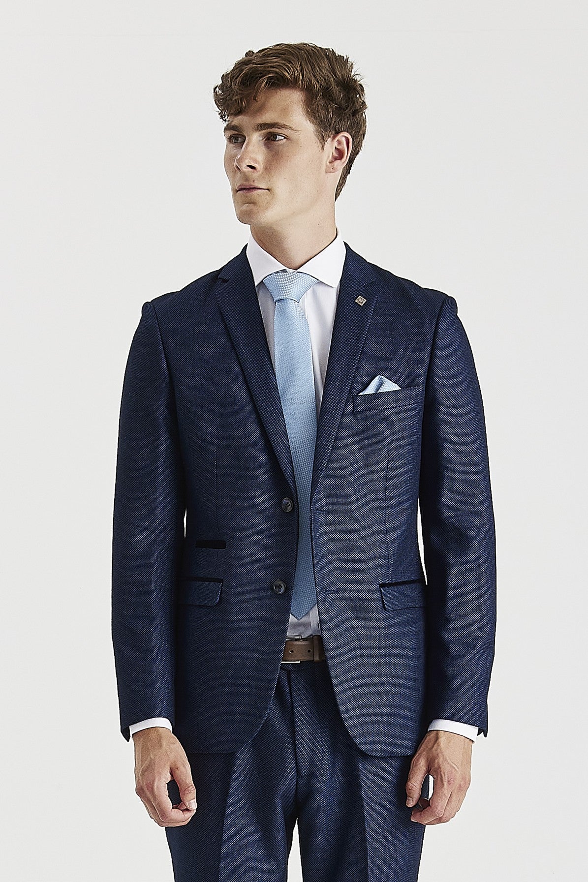 Waist-up front view of a men's navy birdseye suit jacket paired with a crisp white shirt, light blue tie, and matching pocket square.