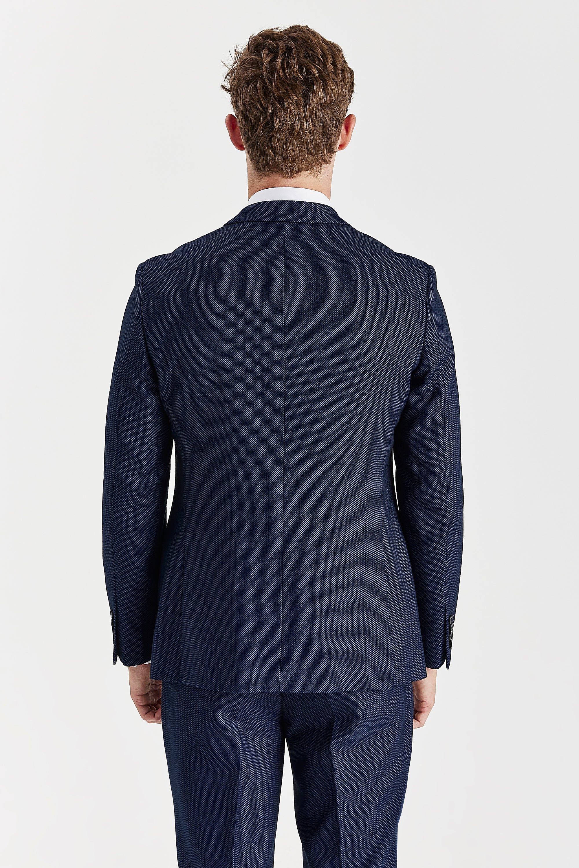 Back view of a navy birdseye suit jacket and matching trousers with double vents.