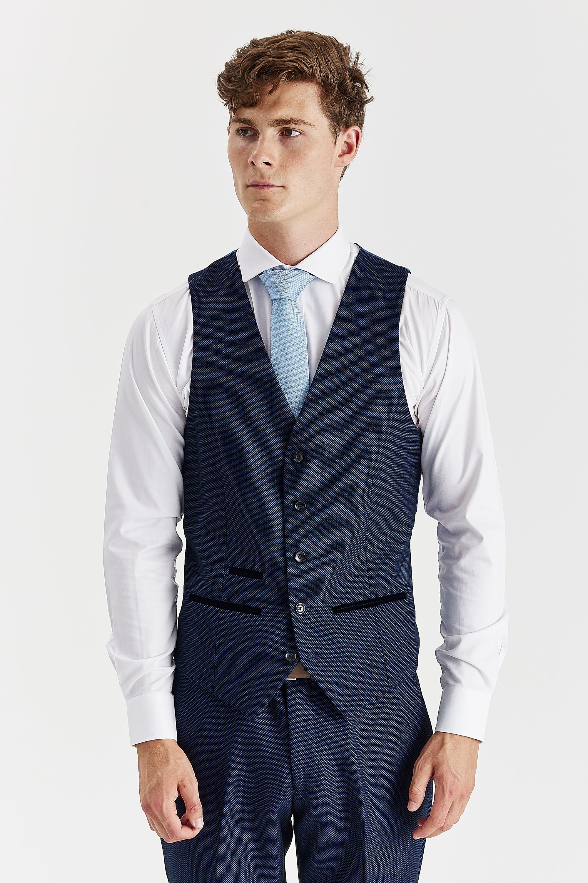 Front view of a navy birdseye waistcoat with matching trousers, a white shirt and a light blue tie.