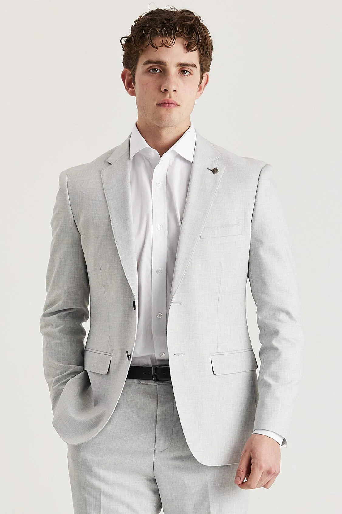 Waist-up front view of a man wearing a tailored silver men's suit jacket over a white shirt with matching silver pants