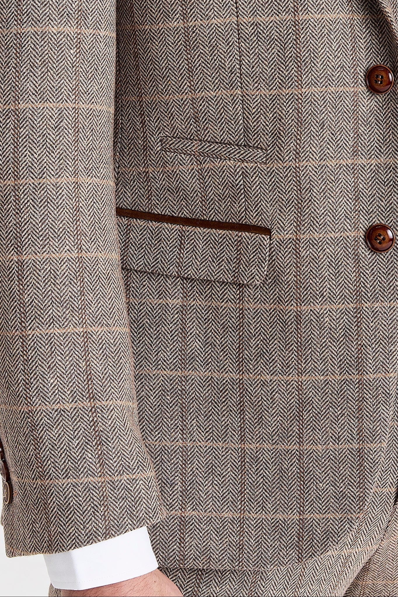 Close-up view of the brown herringbone tweed check blazer showing the textured woven surface, windowpane check, brown suede trim, front flap pocket and brown buttons.