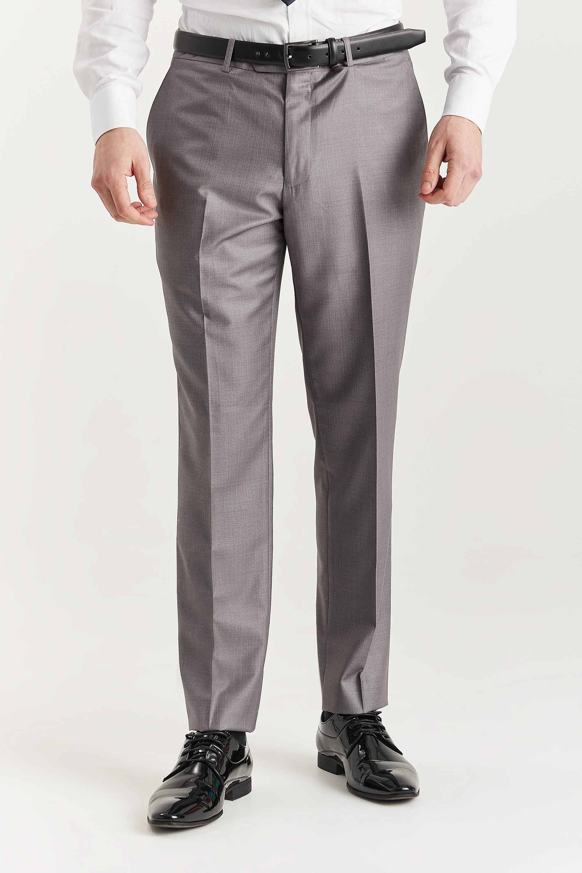 Front view of grey trousers worn with a white shirt, black belt and black shoes