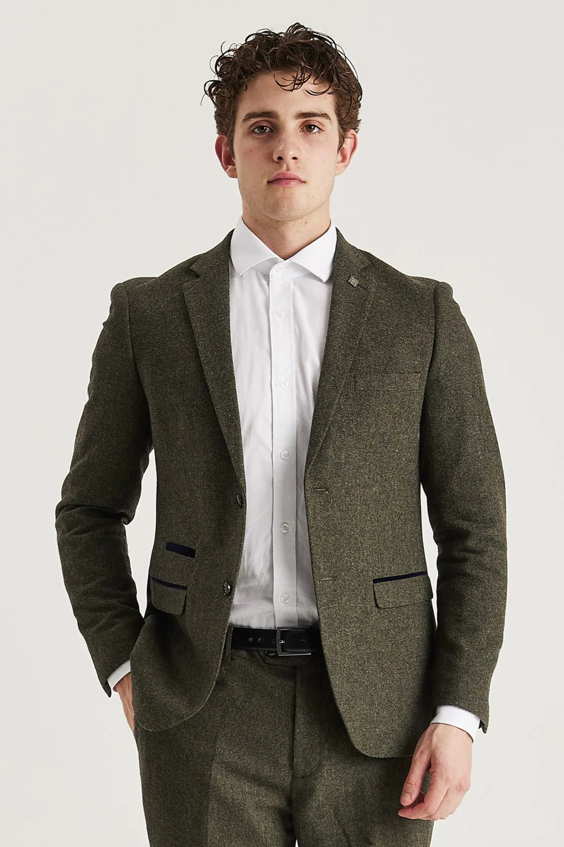 Front view of the green tweed blazer, worn with matching trousers, a white shirt and a black belt.