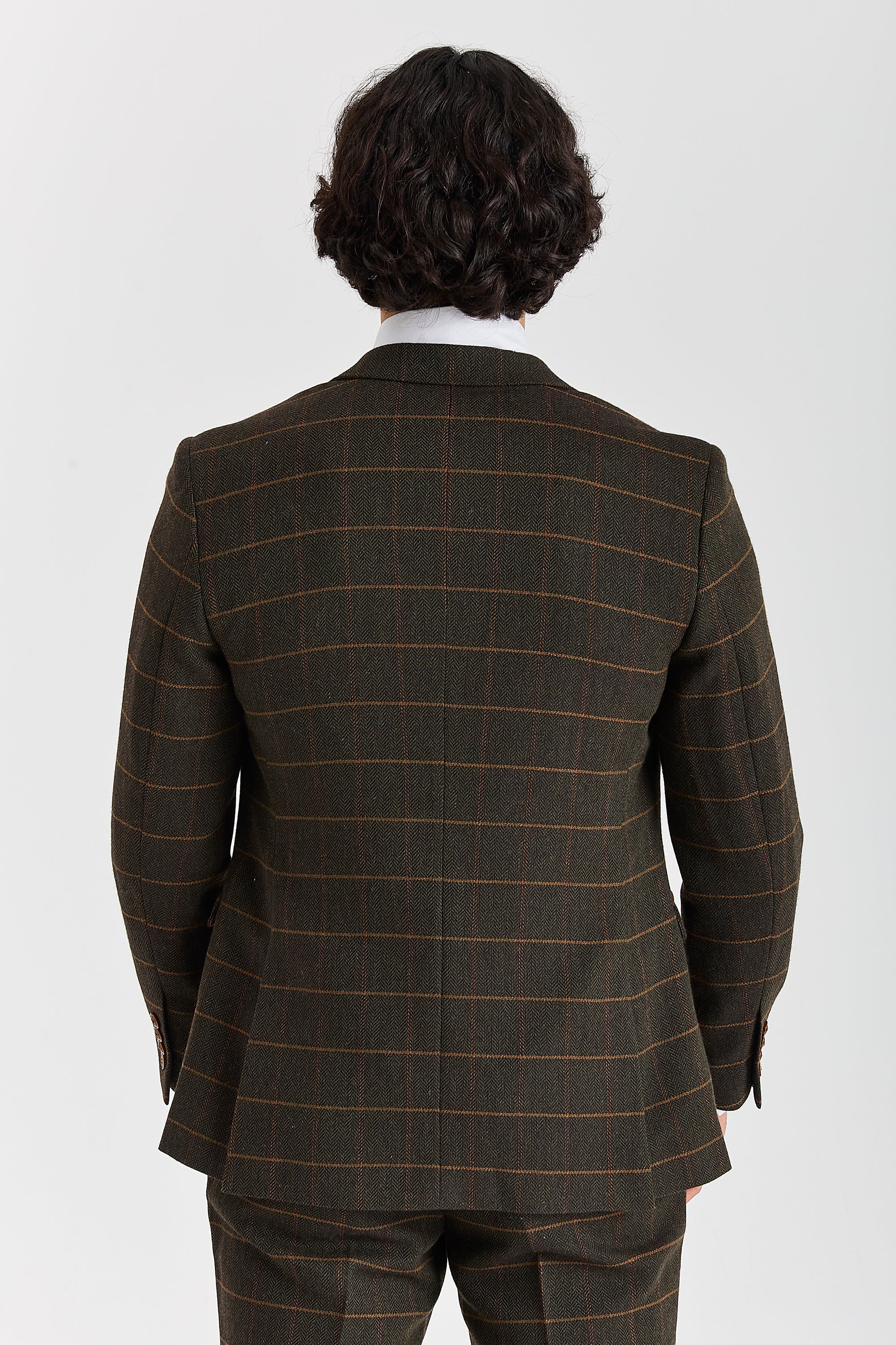 Back view of a Harris green herringbone tweed suit jacket with a tan windowpane check and matching trousers.