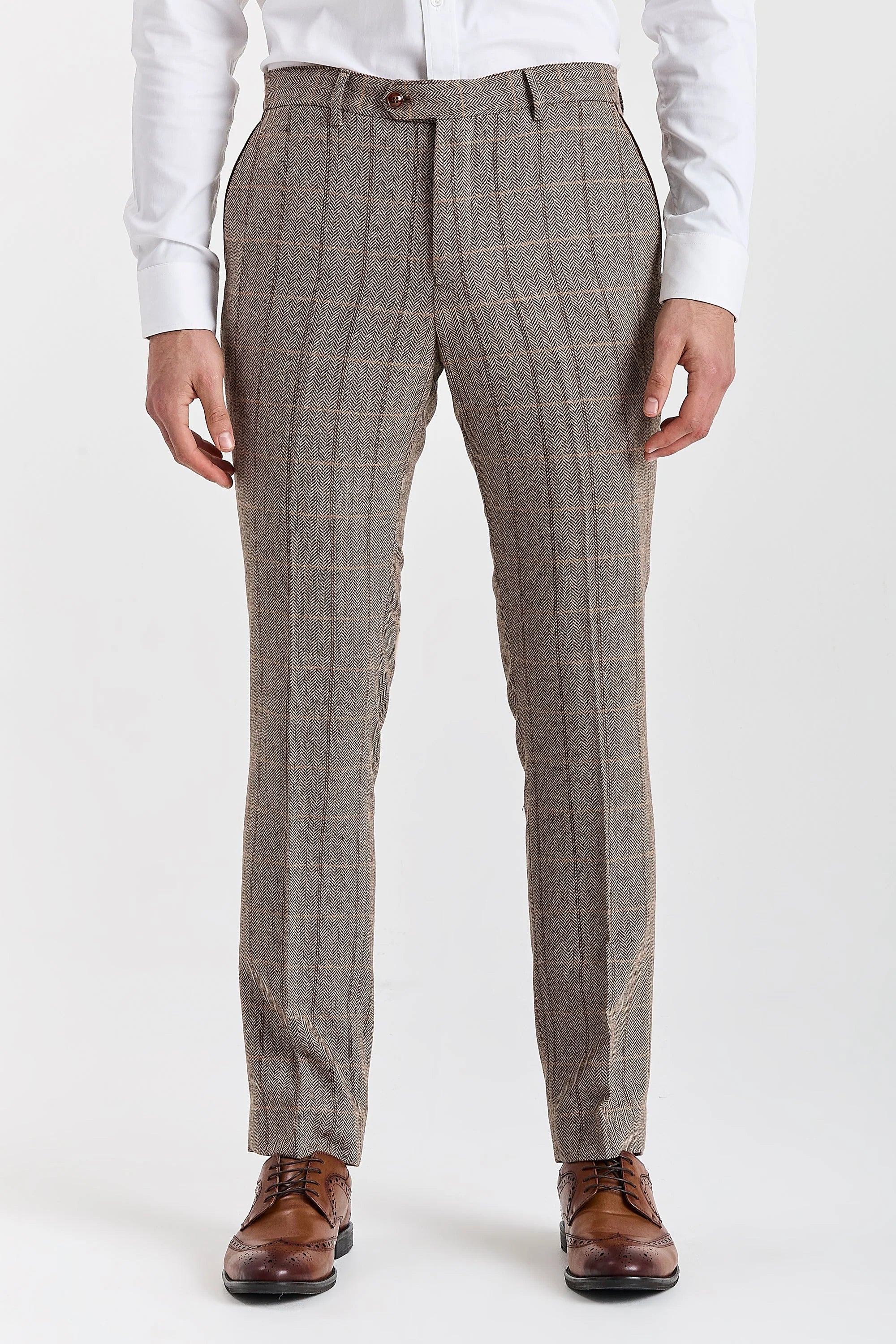 Close-up front view of tailored brown herringbone tweed suit trousers featuring a windowpane check pattern, styled with a white shirt and brown brogue shoes