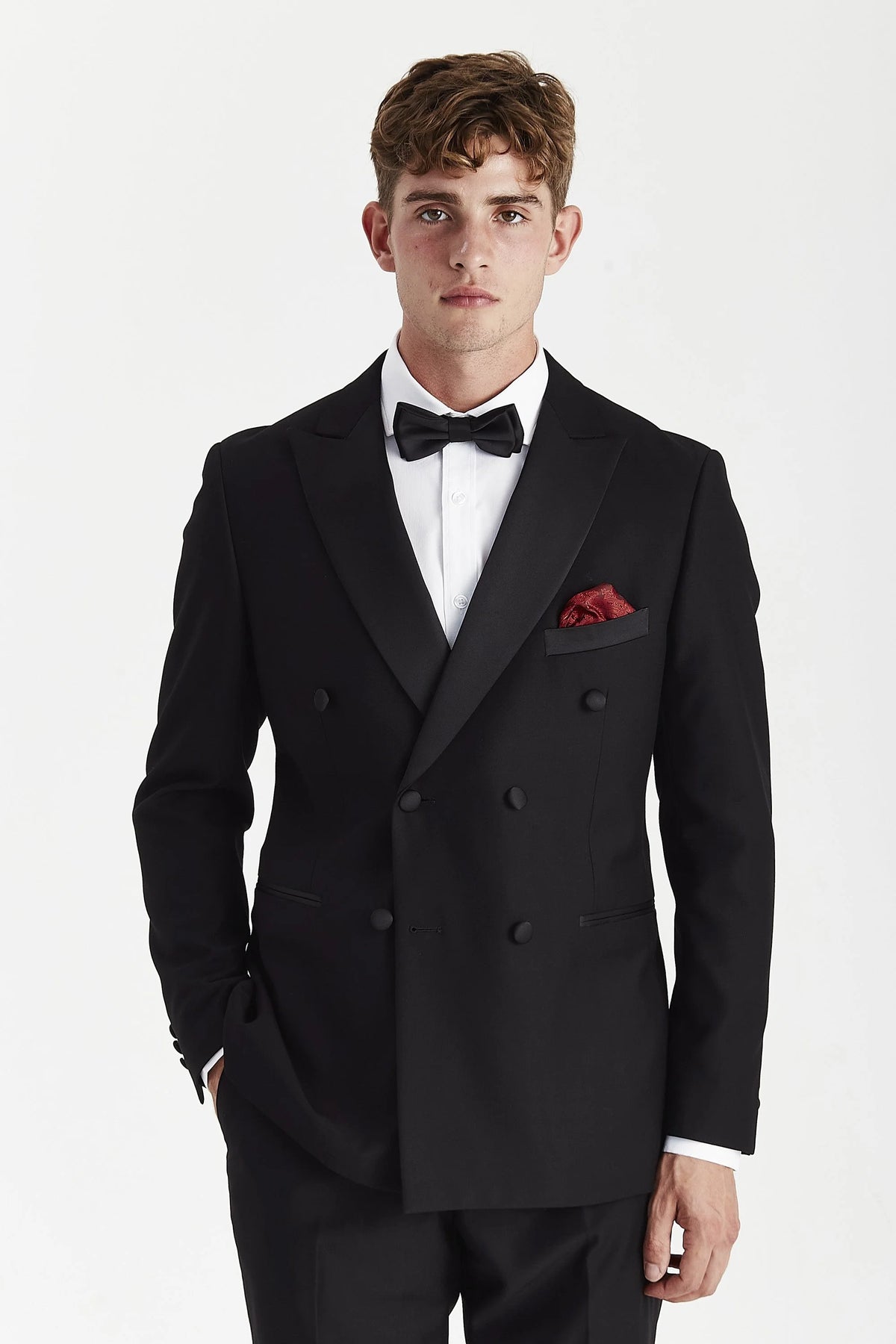 Black double-breasted tuxedo jacket on a model, with satin peak lapels.