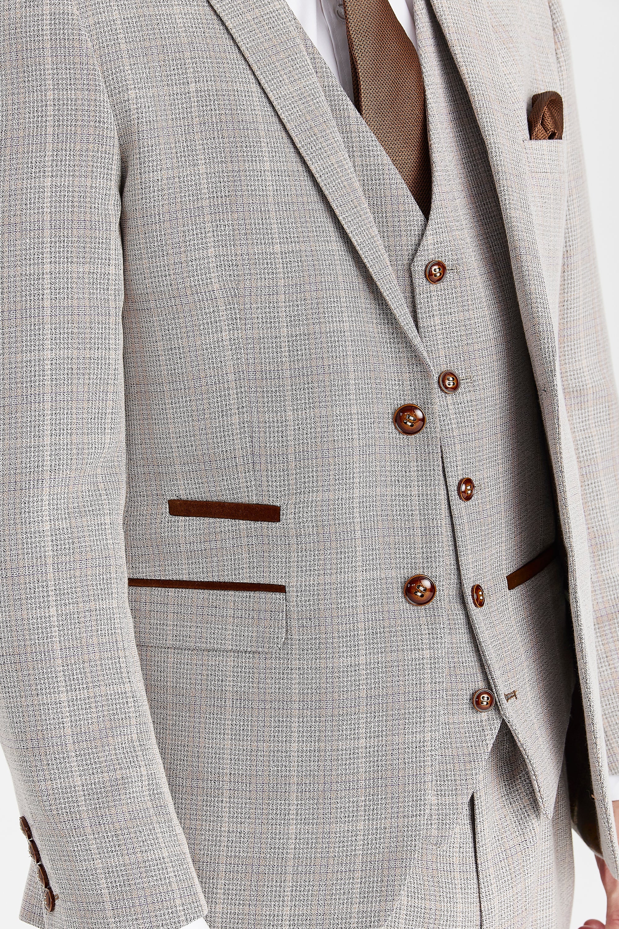 Detail view of beige check jacket and waistcoat fabric with brown buttons, brown pocket trim, brown tie and pocket square.