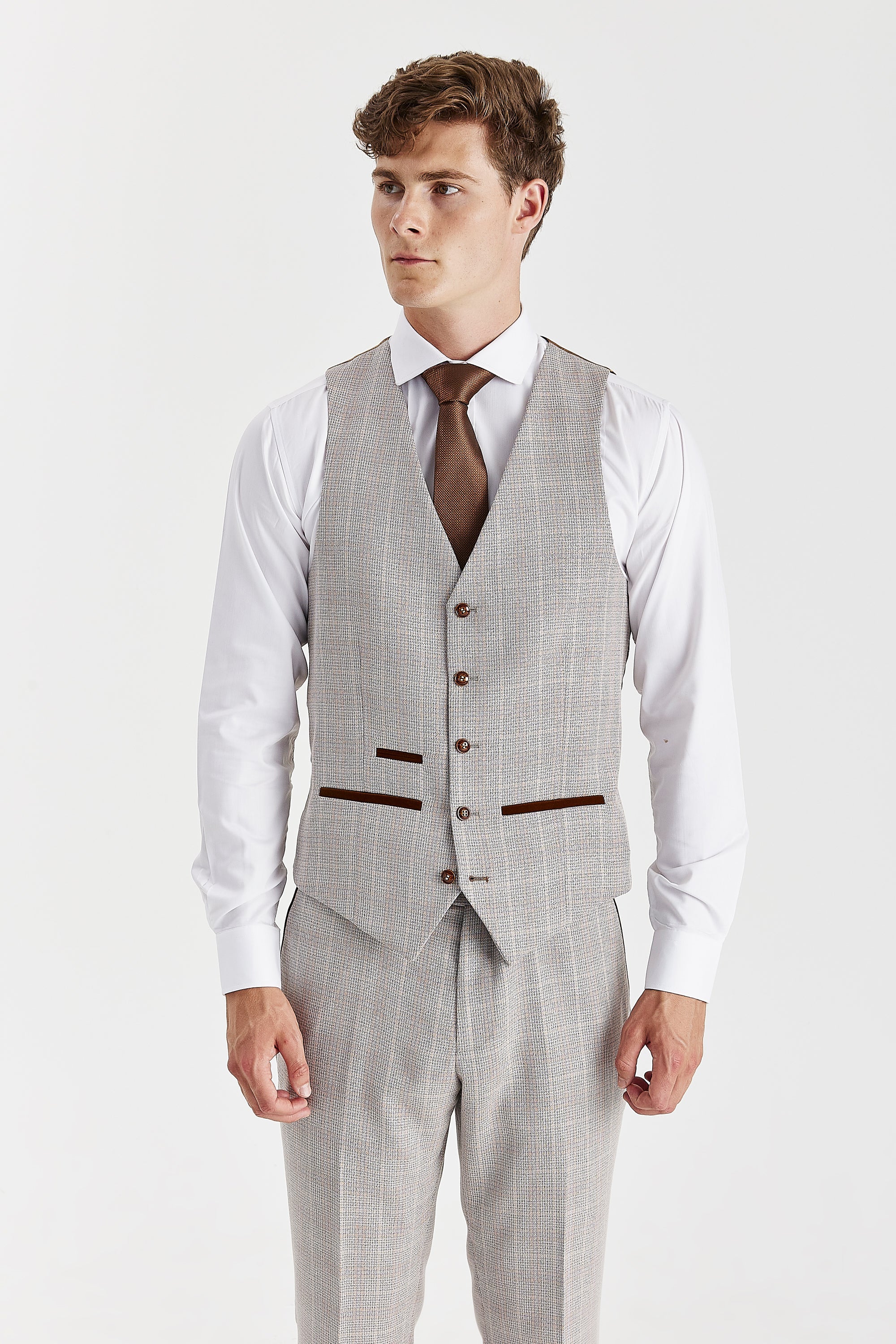 Front view of the beige waistcoat, worn with matching trousers, a white shirt and a brown tie.