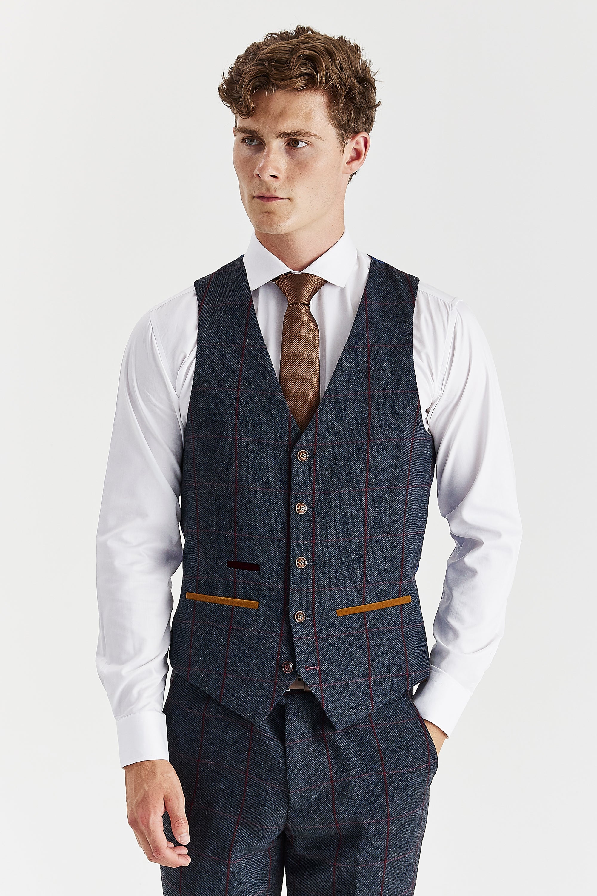 Front view of the navy tweed windowpane waistcoat with brown buttons and suede pocket trimmings, worn with matching trousers, a white shirt and a brown tie.