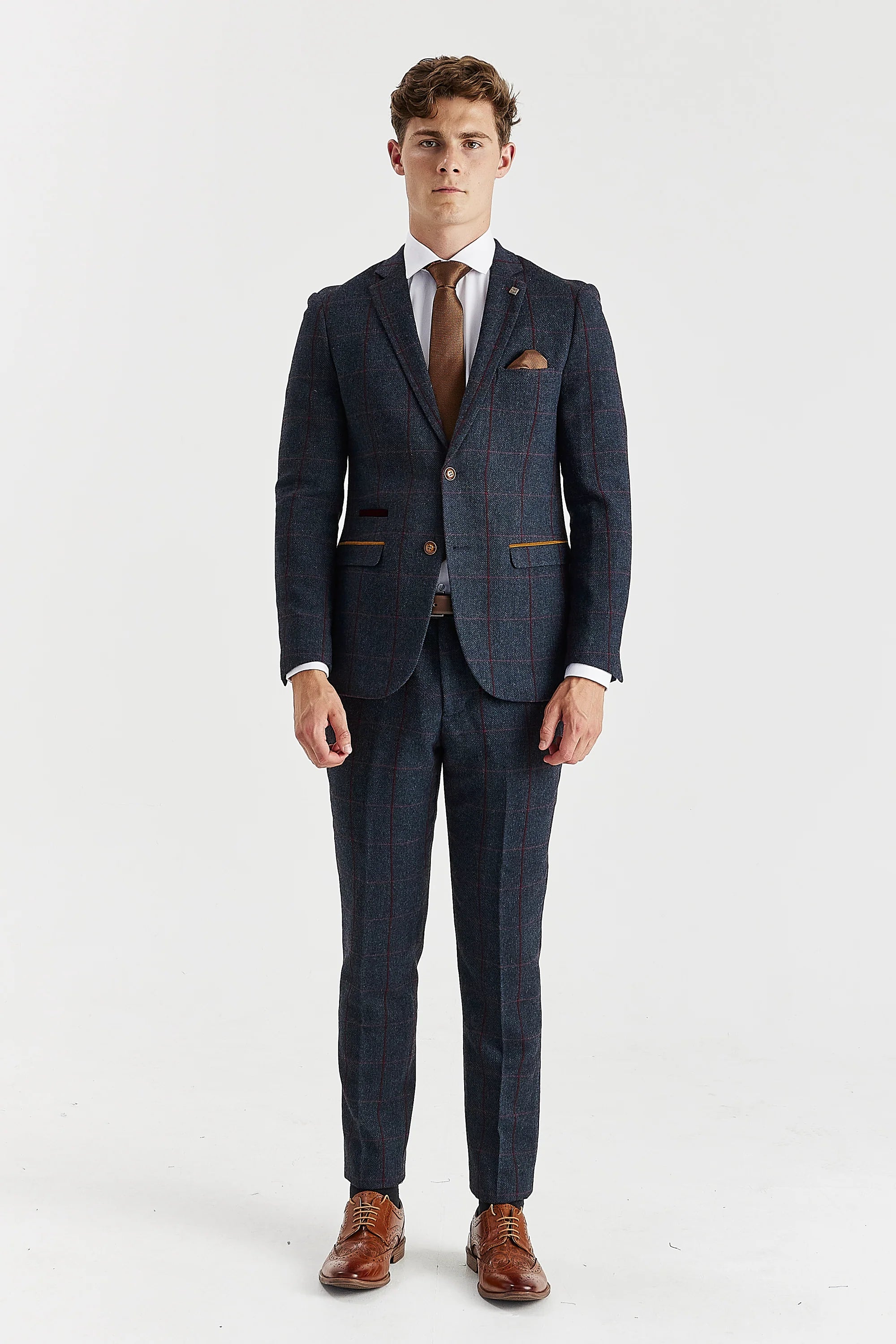Full-length view of a man modeling a navy tweed two-piece suit with a burgundy windowpane check, paired with brown shoes
