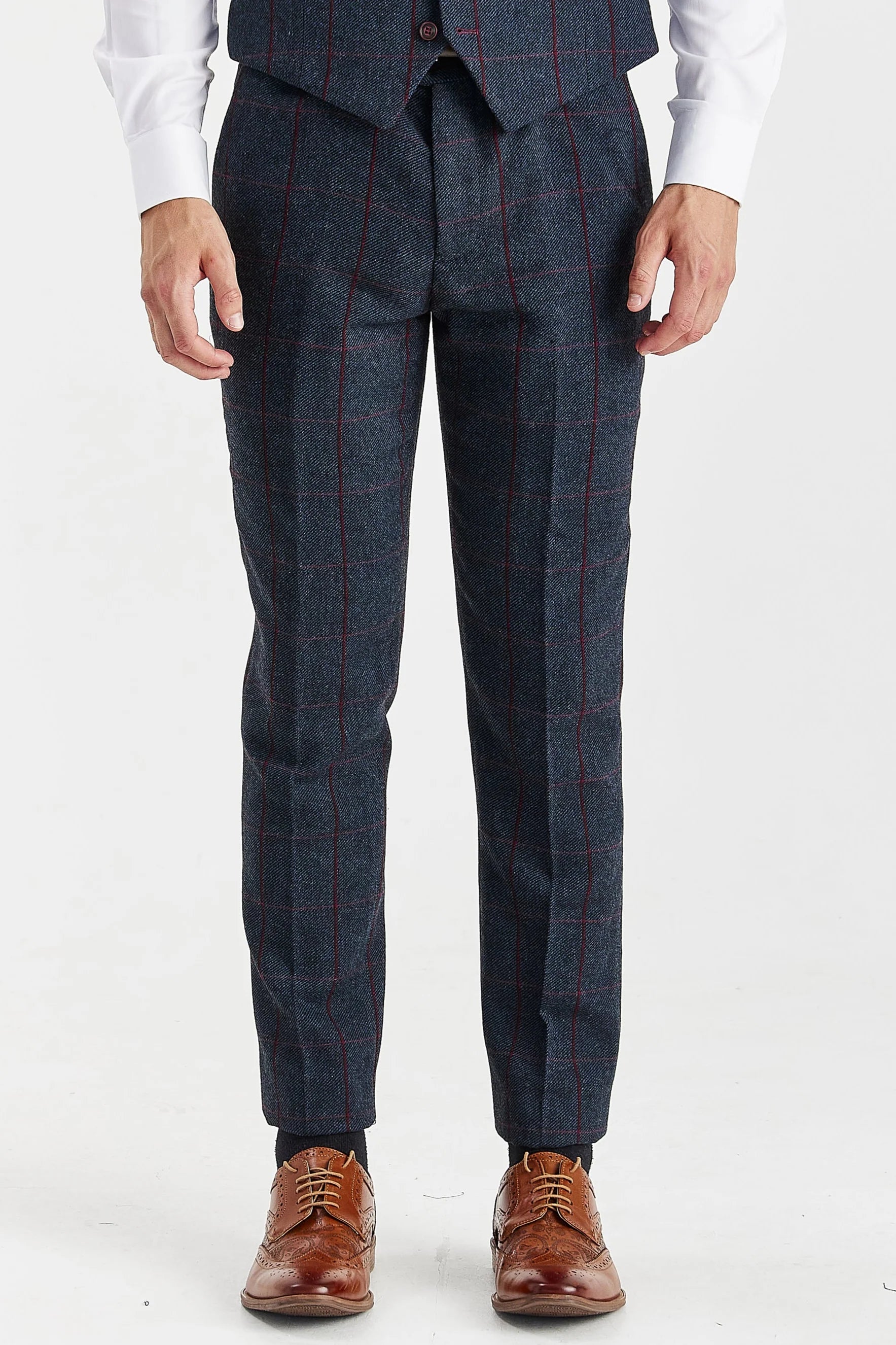 Close-up front view of men's navy tweed suit trousers and a waistcoat featuring a burgundy check, paired with brown shoes.