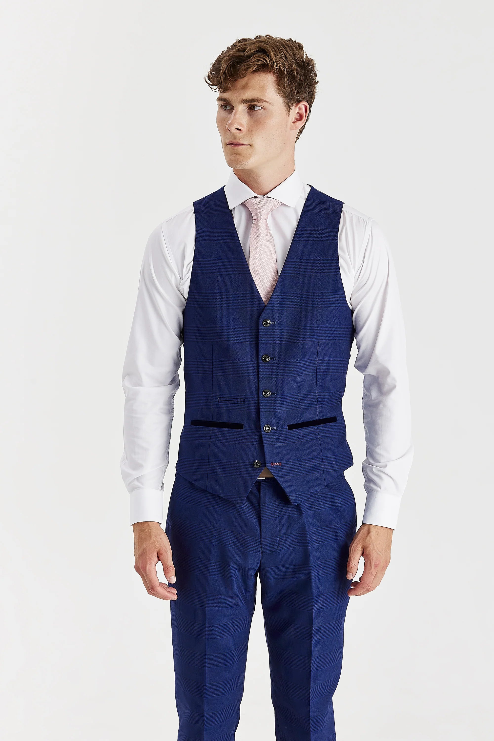 Front view of the blue glen check waistcoat with suede pocket trimmings, worn with matching trousers, a white shirt and a pale pink tie.
