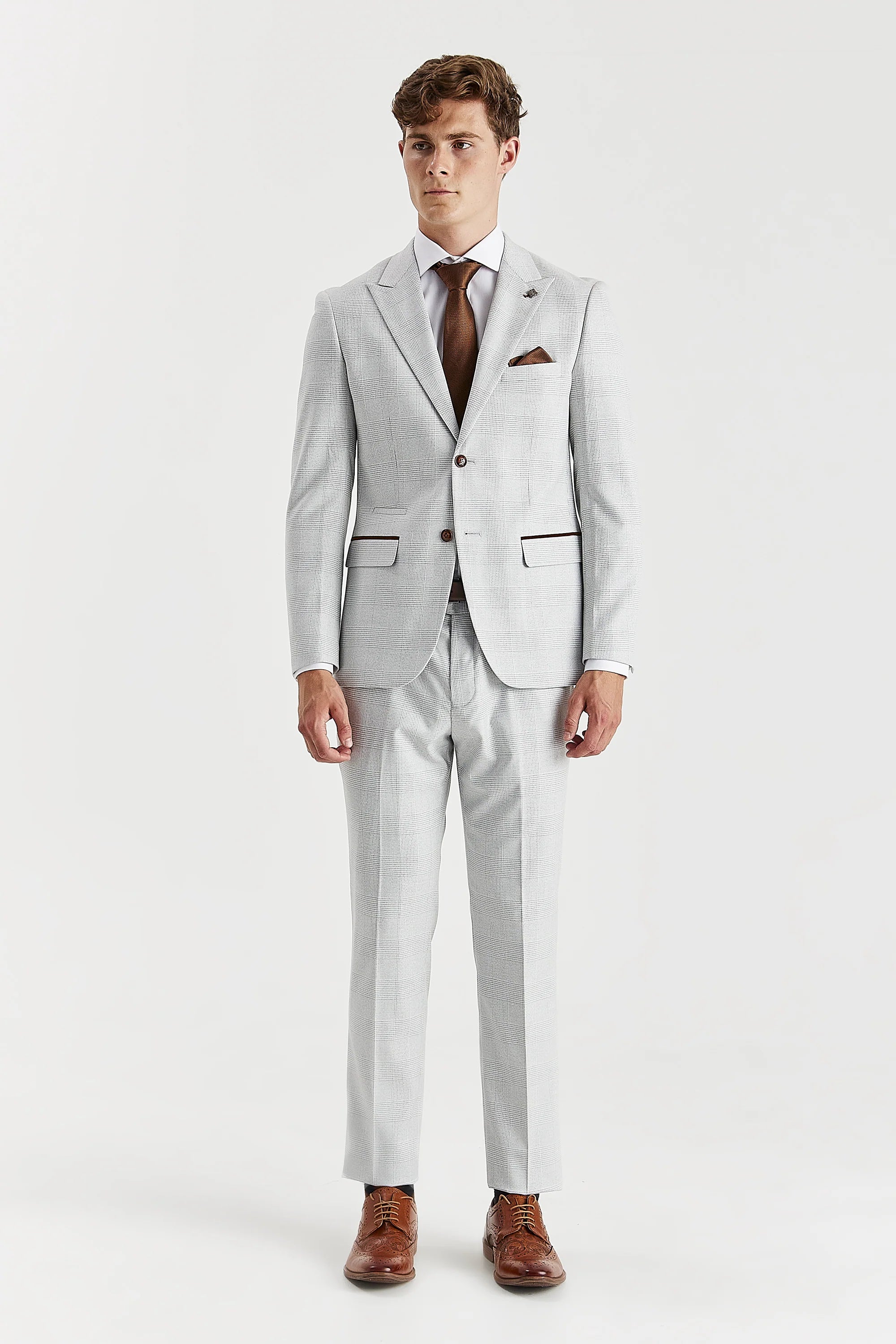 Full front view of stone glen check two-piece suit worn with a white shirt, brown tie and brown brogues