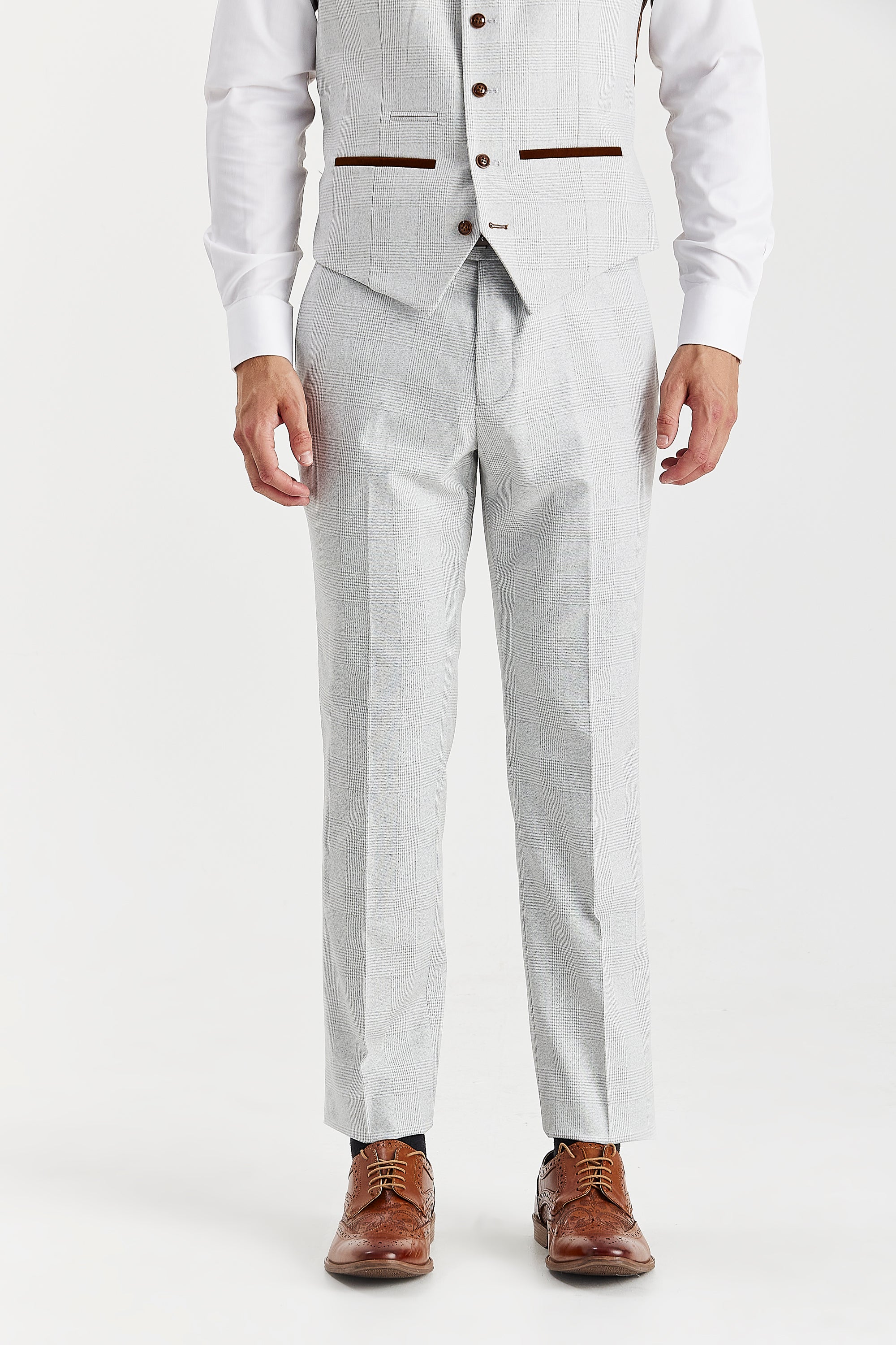 Front view of stone trousers with a glen check pattern, shown with a matching waistcoat, white shirt cuffs and brown shoes.