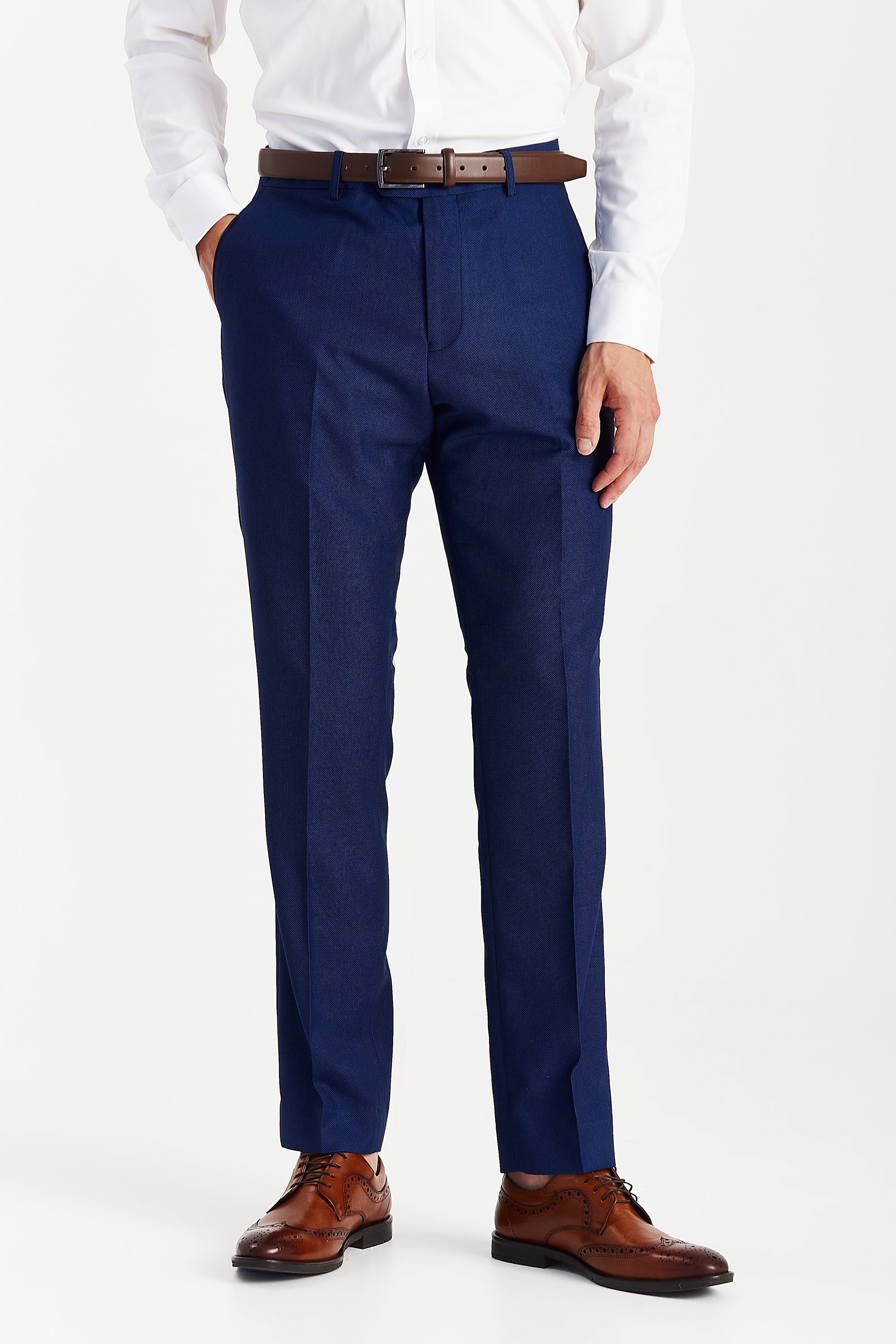 Front view of blue textured suit trousers with a brown belt, white shirt cuffs and brown brogue shoes.