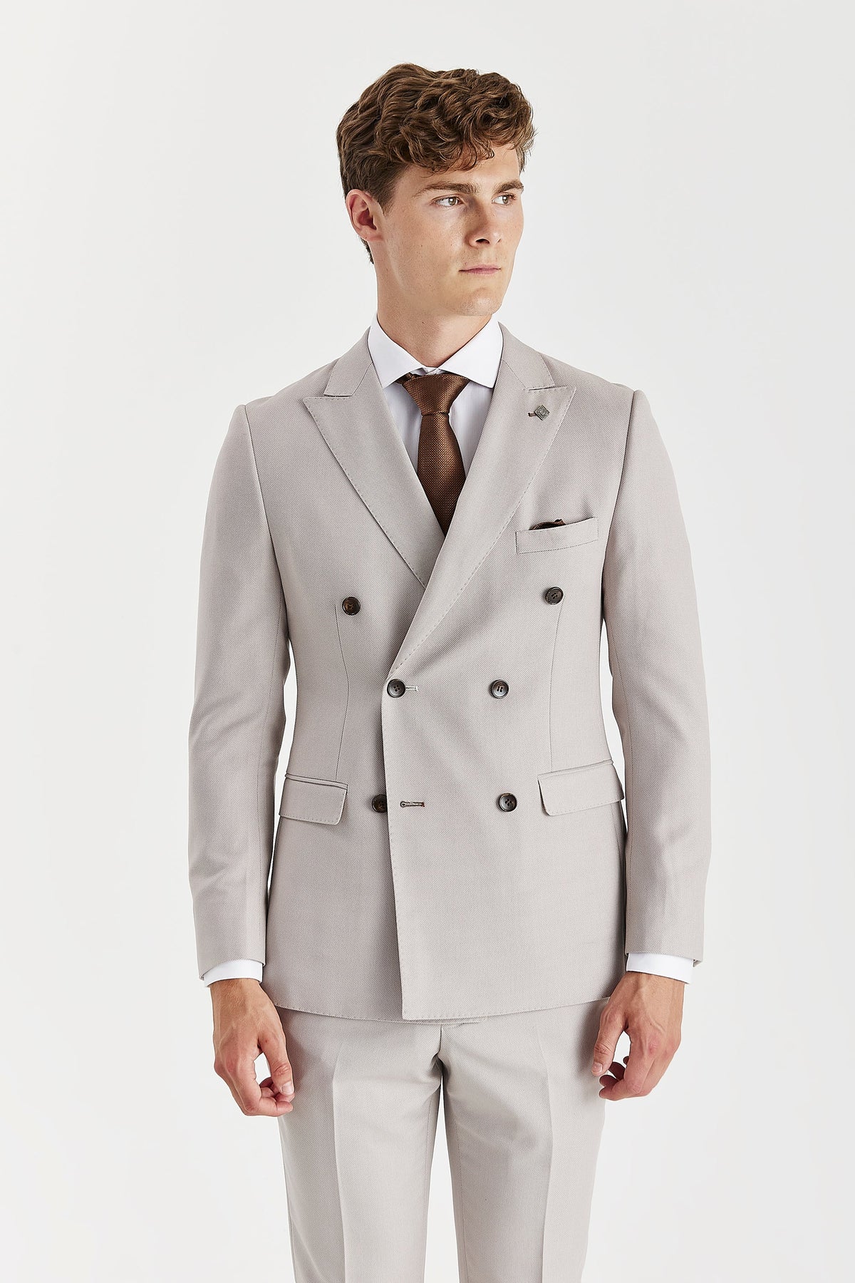 Front view of the stone double-breasted jacket showing peak lapels, six brown buttons and flap pockets.