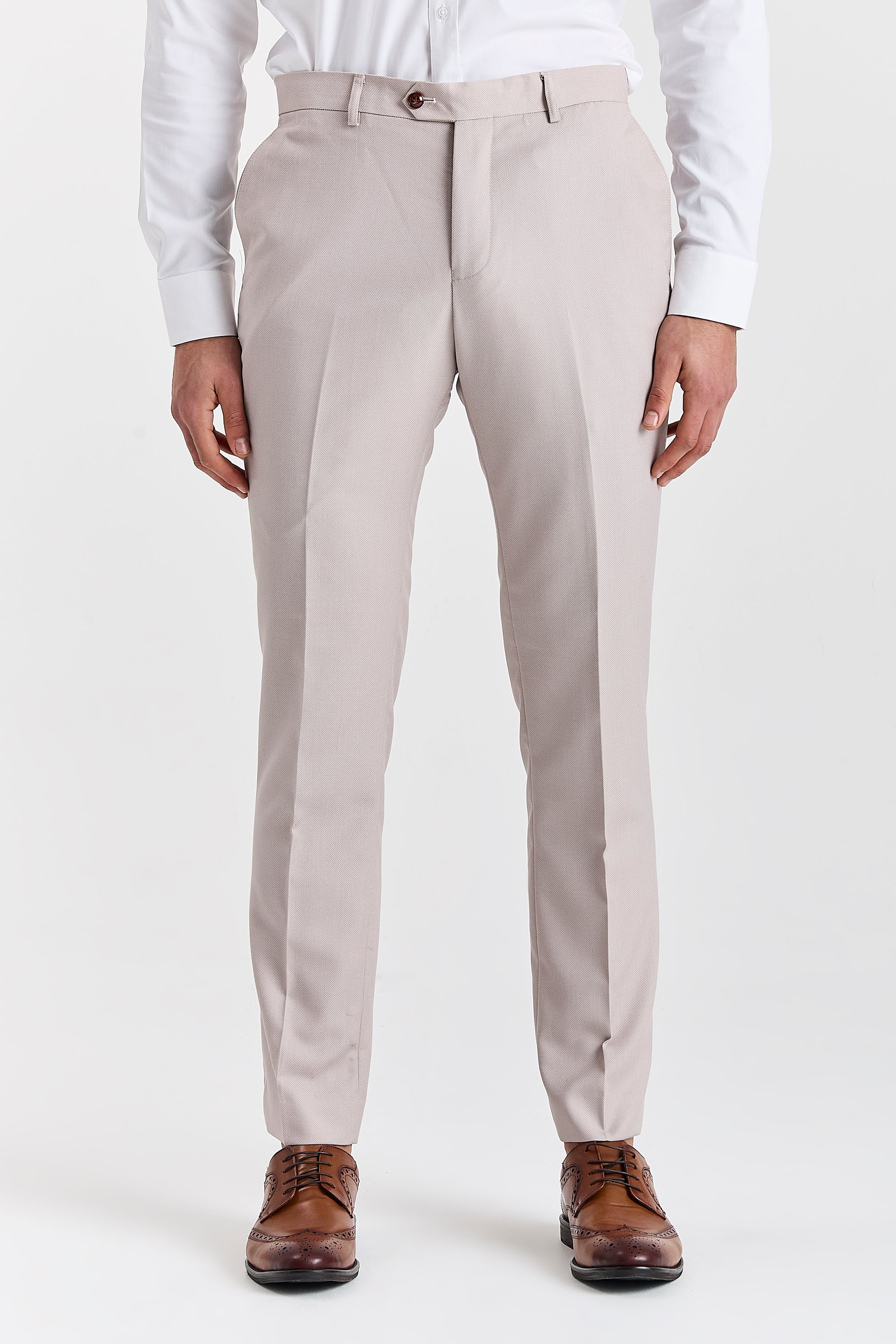 Front view of stone textured suit trousers with a white shirt, brown buttons and brown brogue shoes.