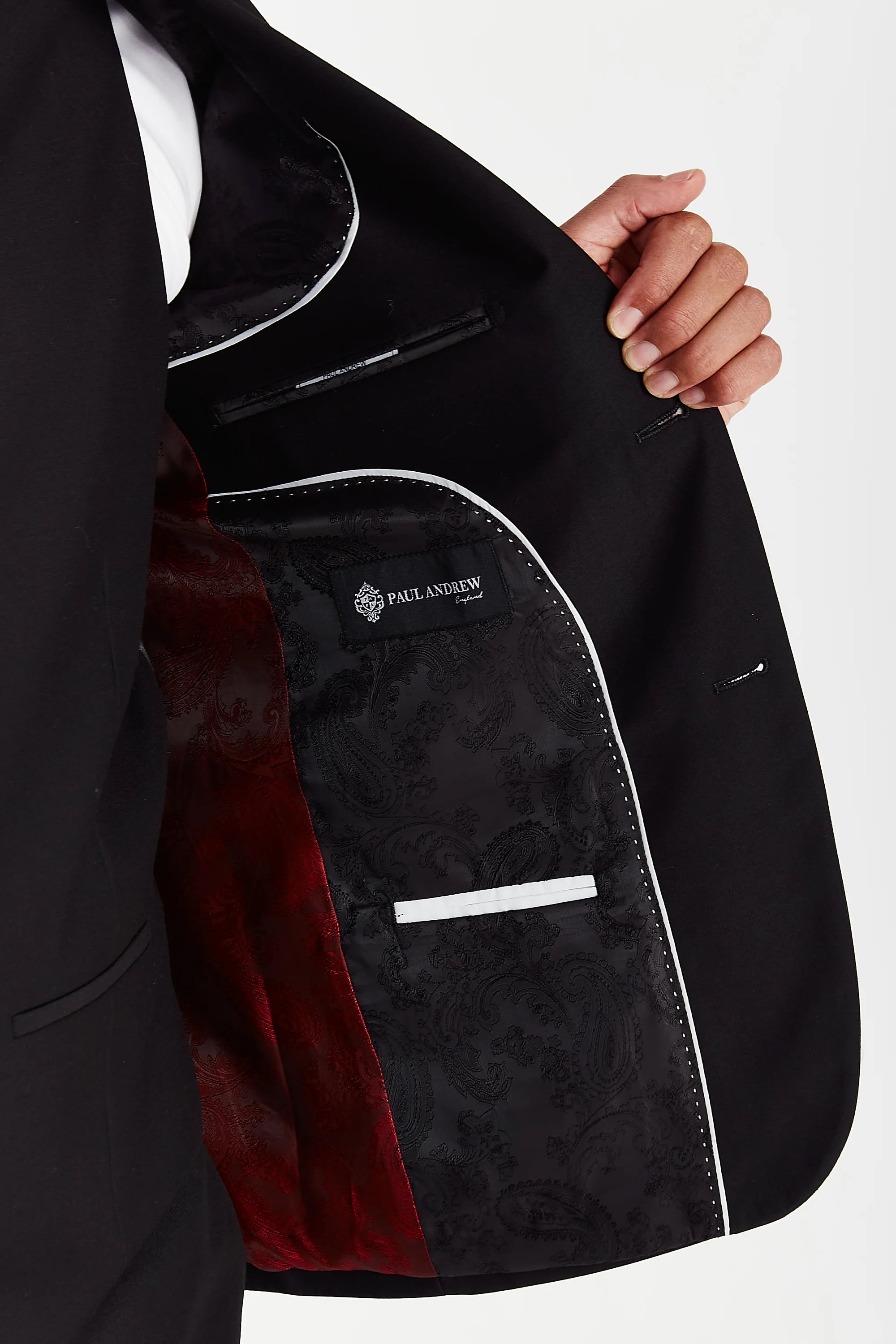 Interior detail of the Parker black blazer, revealing a two-tone lining with black and deep red paisley patterns, finished with the Paul Andrew brand label.