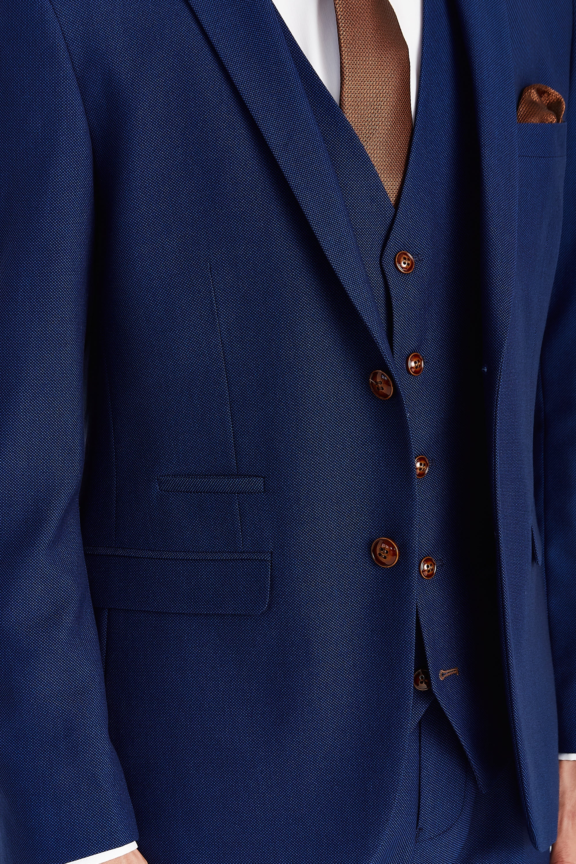 Close-up view of the blue textured blazer showing the finely woven surface, a front flap pocket, matching upper pocket trim and brown buttons.