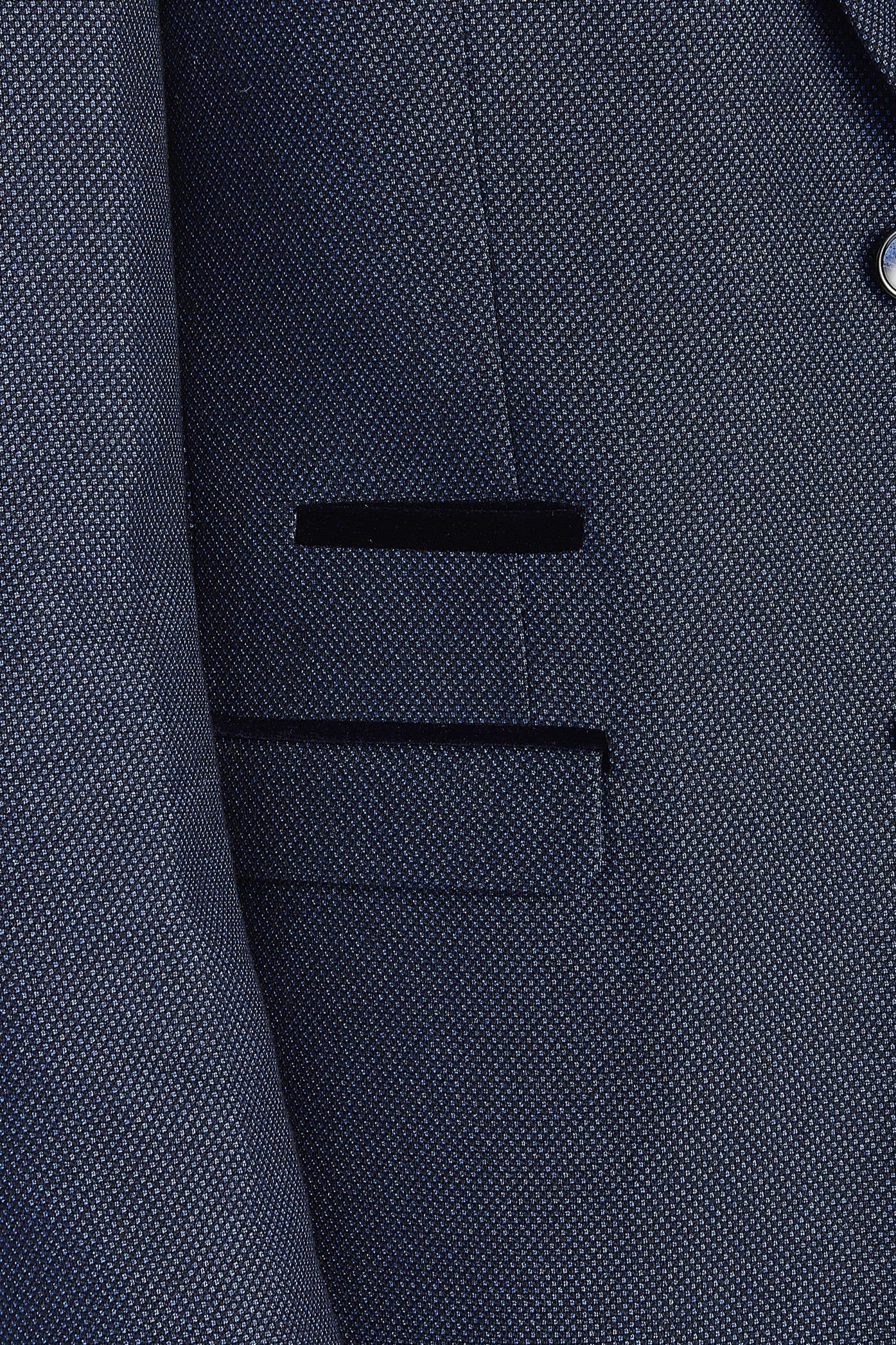 Close-up view of the navy blazer showing the textured woven surface, front flap pocket and a contrast trim detail above the pocket.