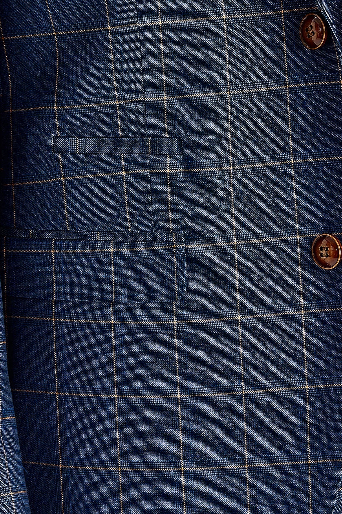 Close-up view of the navy check blazer showing the check pattern, brown buttons, a front flap pocket.