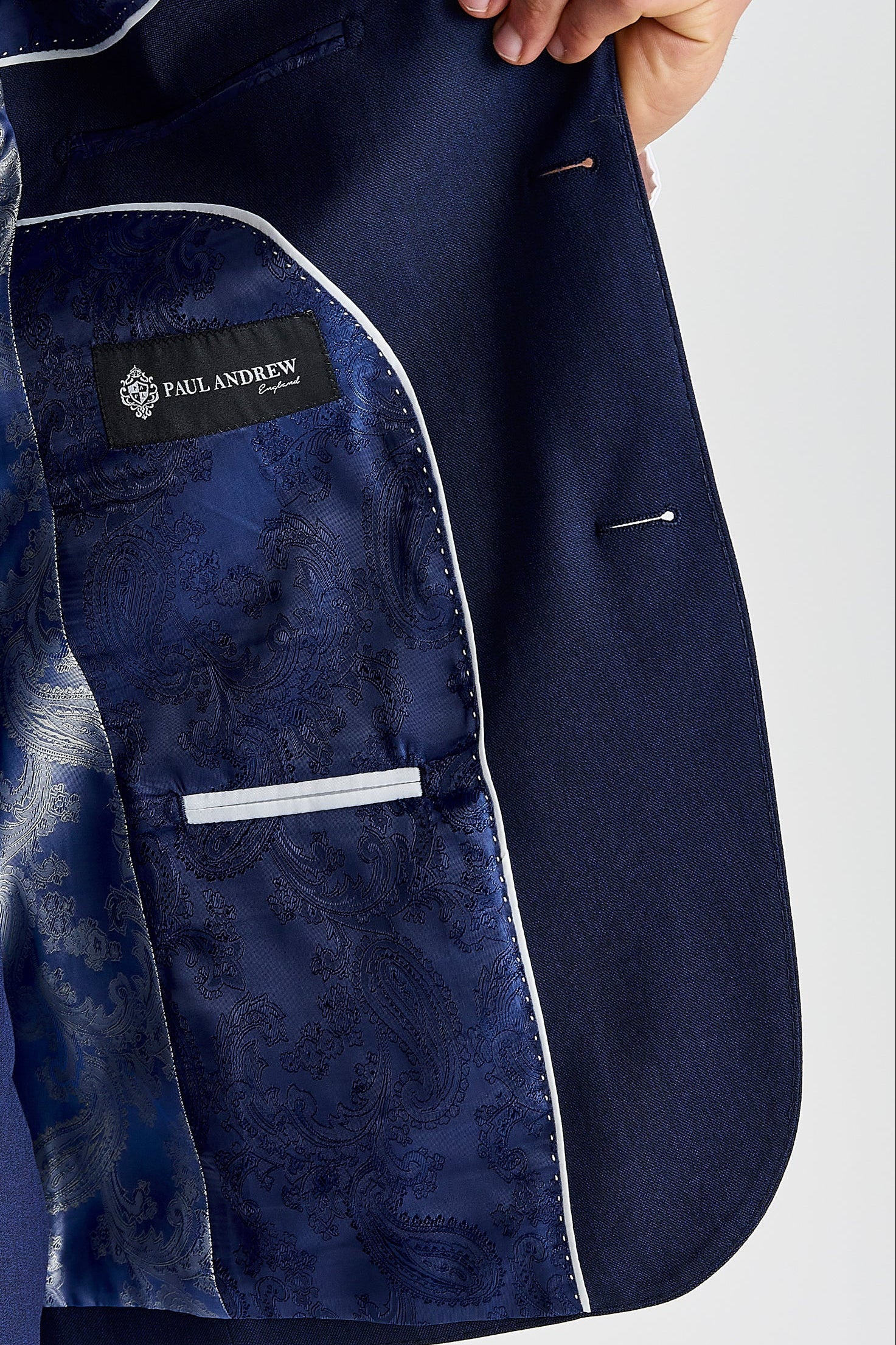 Interior view of the navy blazer with navy paisley lining and a visible Paul Andrew logo label.