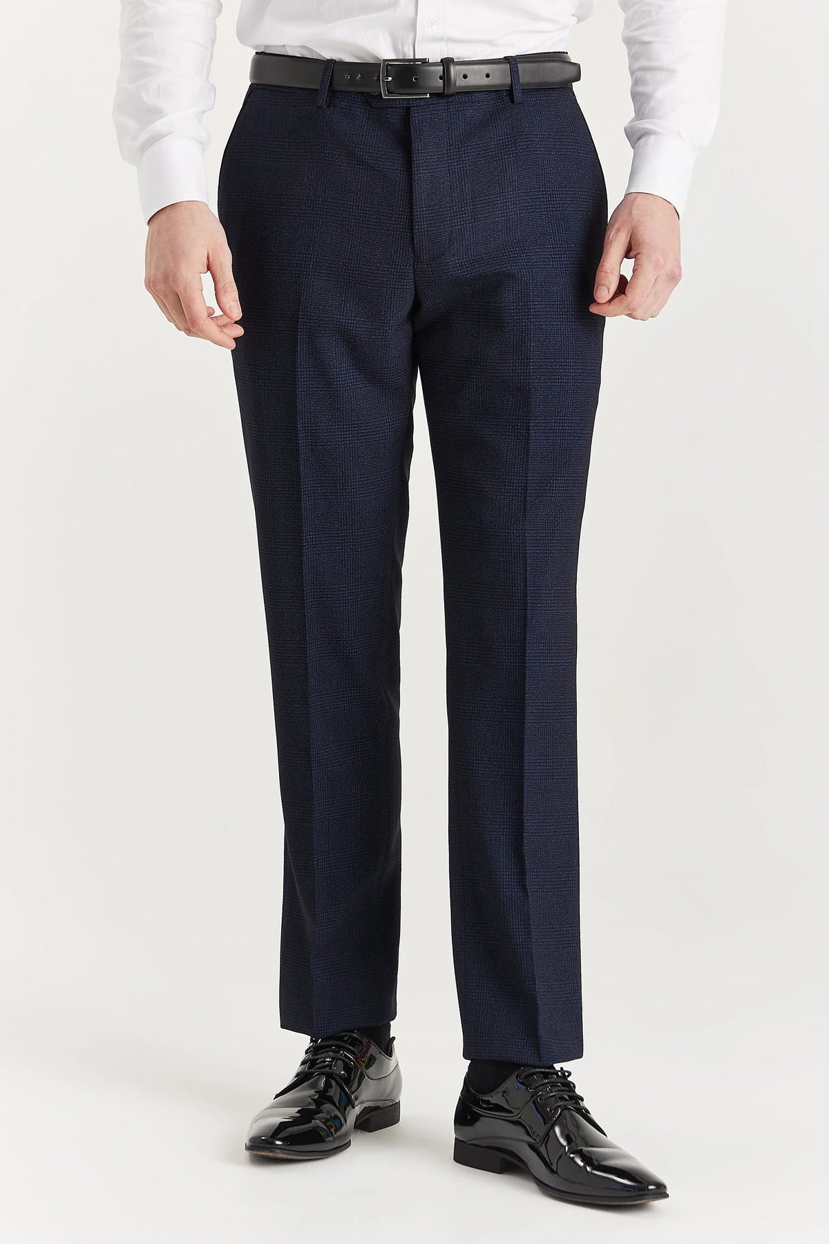 Navy check trousers with a flat front, belt loops and pressed leg creases, shown with a black belt and black brogues.