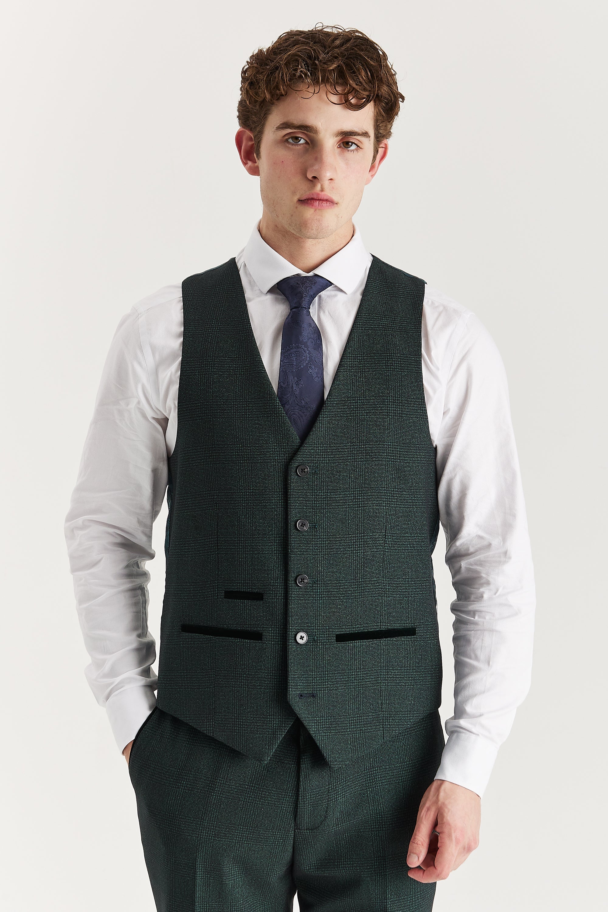 Front view of the olive glen check waistcoat with suede pocket trimmings, worn with matching trousers, a white shirt and a navy tie.