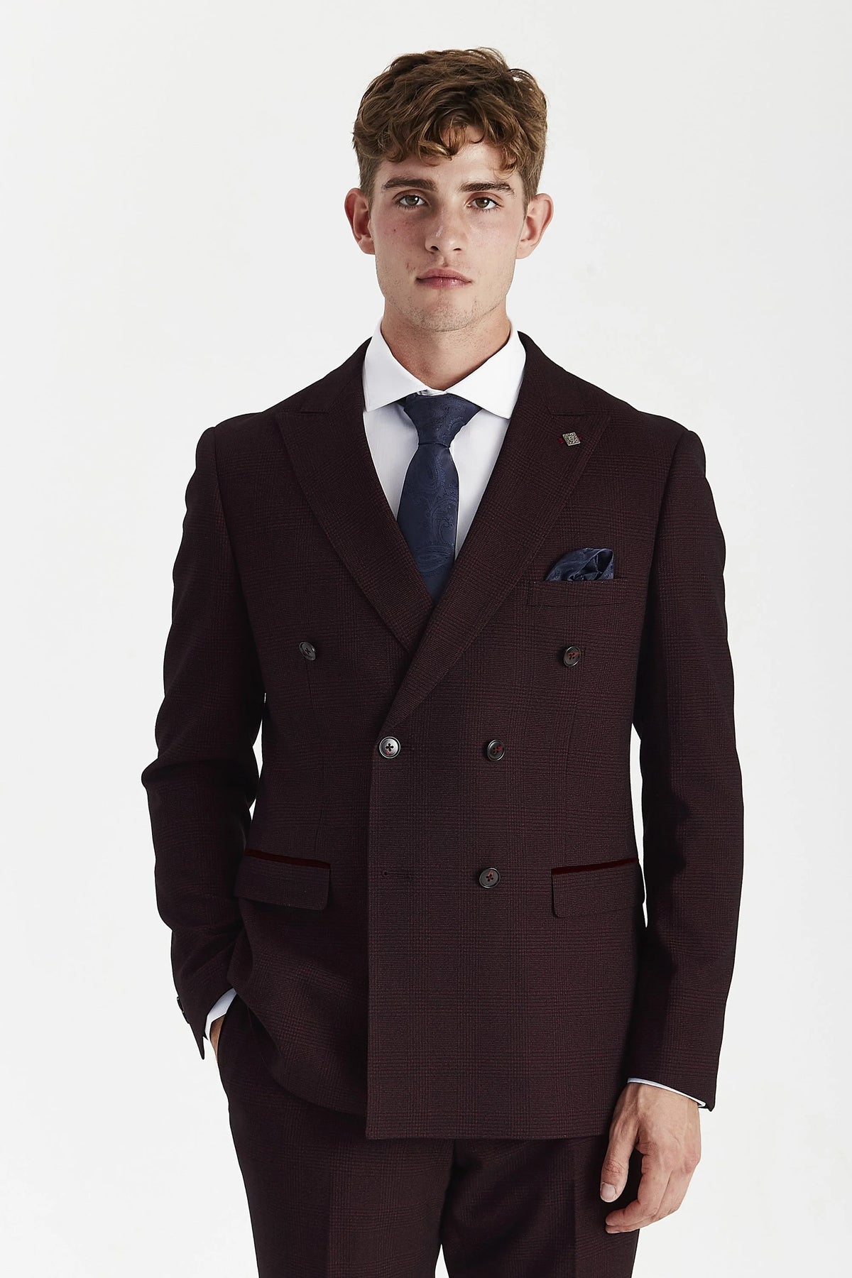Wine check double-breasted jacket on a model, with peak lapels, two rows of dark buttons and flap pockets.