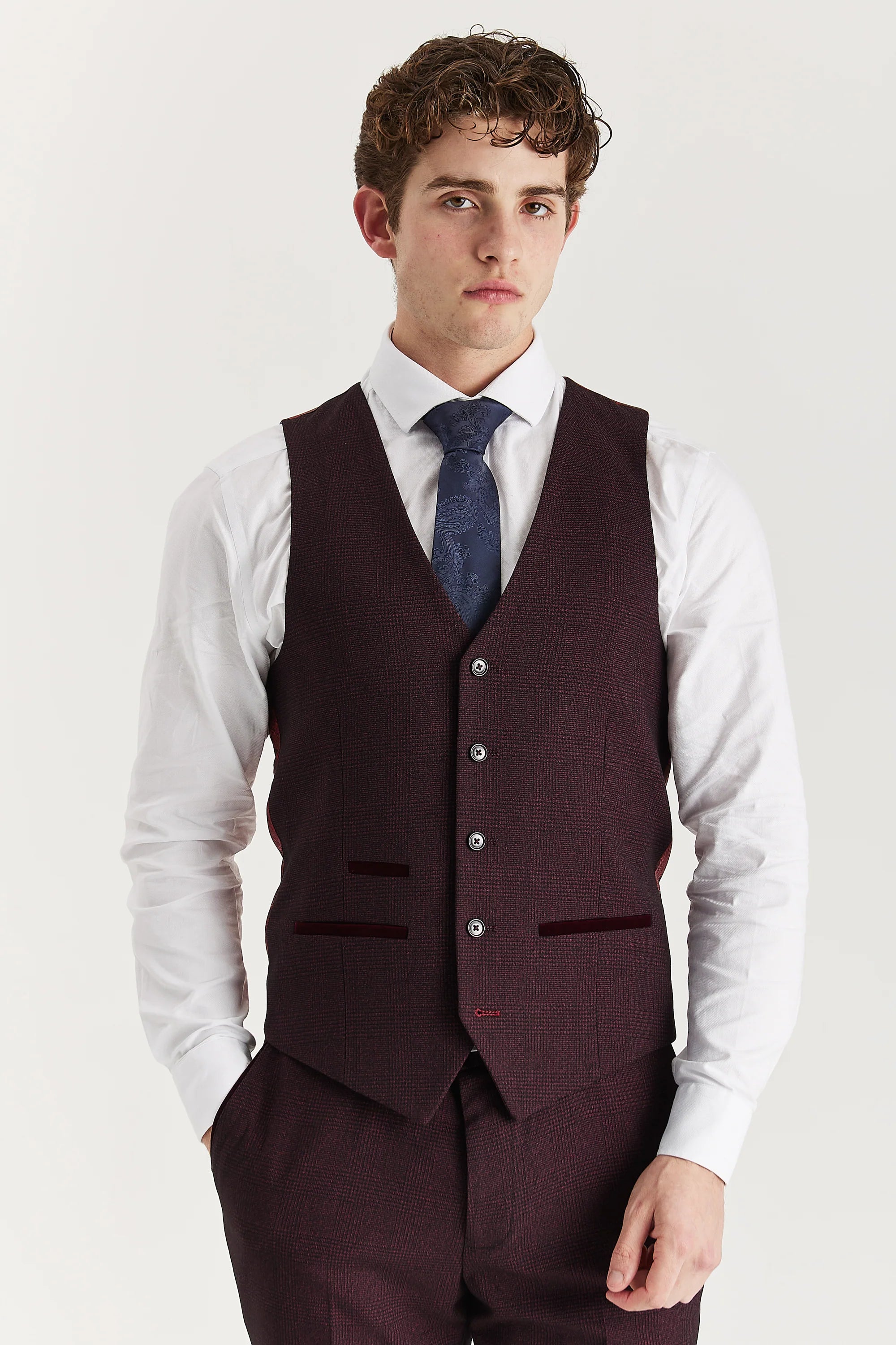 Front view of the wine glen check waistcoat with suede pocket trimmings, worn with matching trousers, a white shirt and a navy tie.