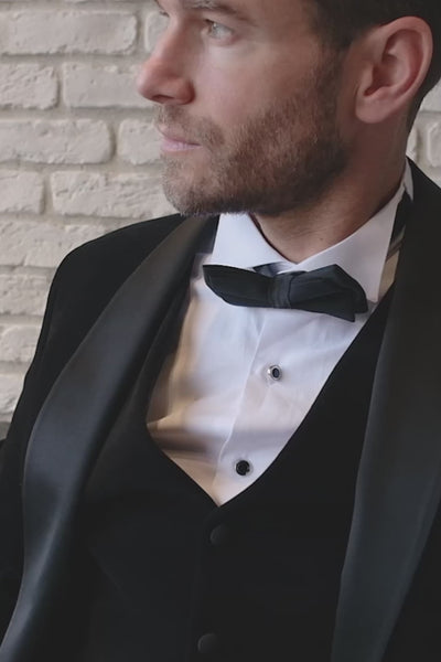 Man seated wearing black velvet dinner jacket and waistcoat with black satin shawl lapels