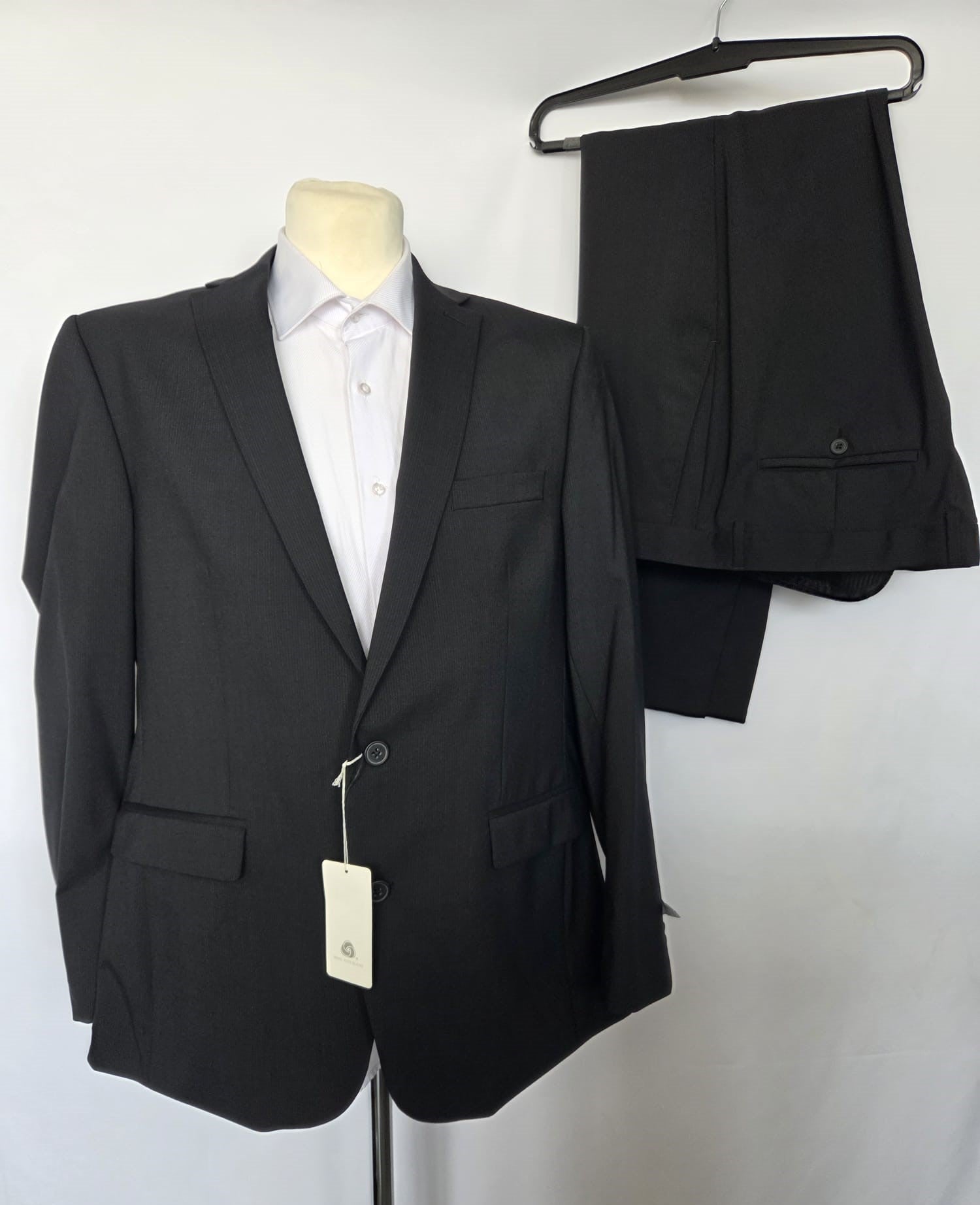 Thomas Goodwin black wool-blend two-piece suit displayed with matching trousers on hanger, modern fit.