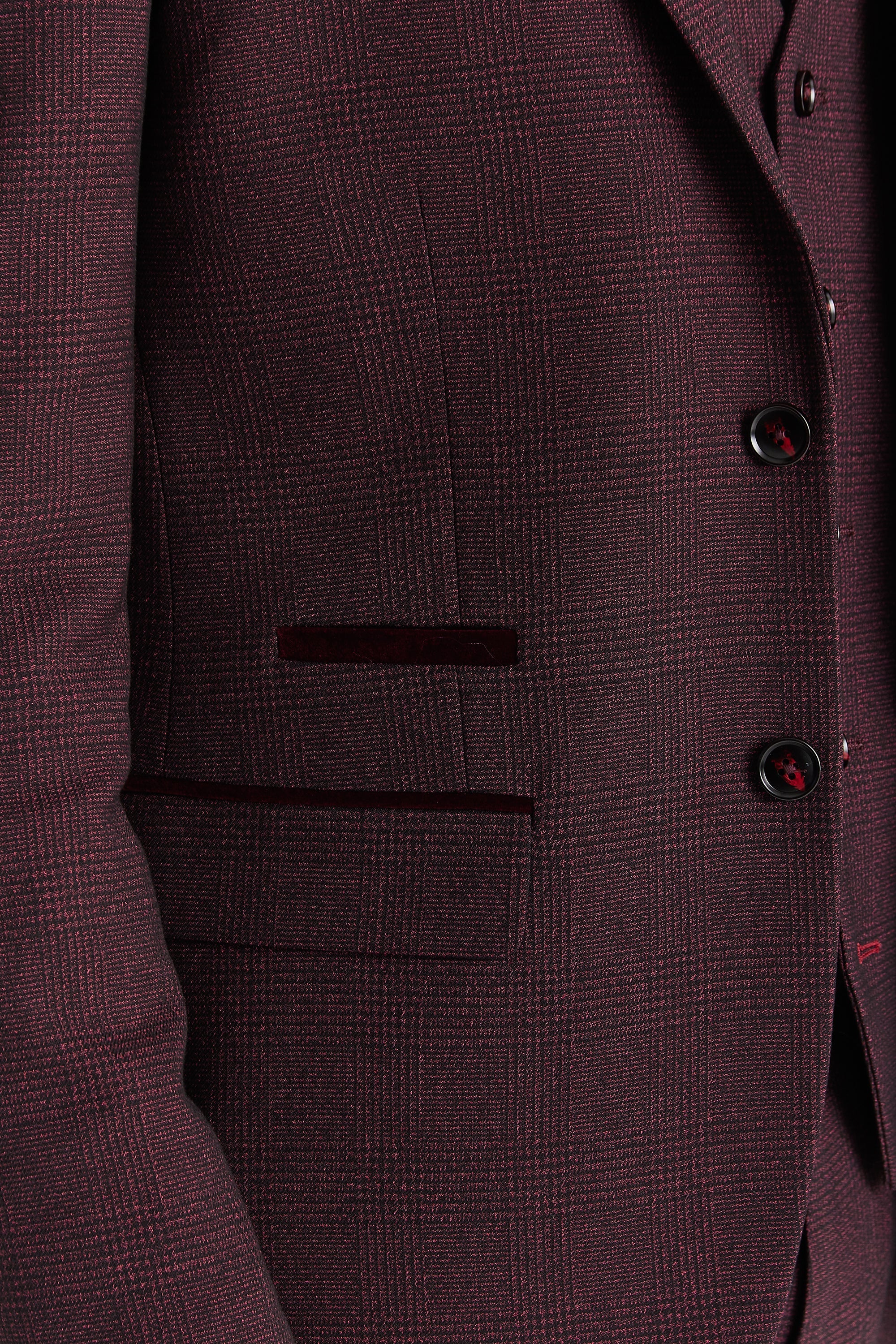 Close-up view of the wine glen check blazer showing the woven check pattern, front flap pocket, dark trim detail above the pocket and black buttons.
